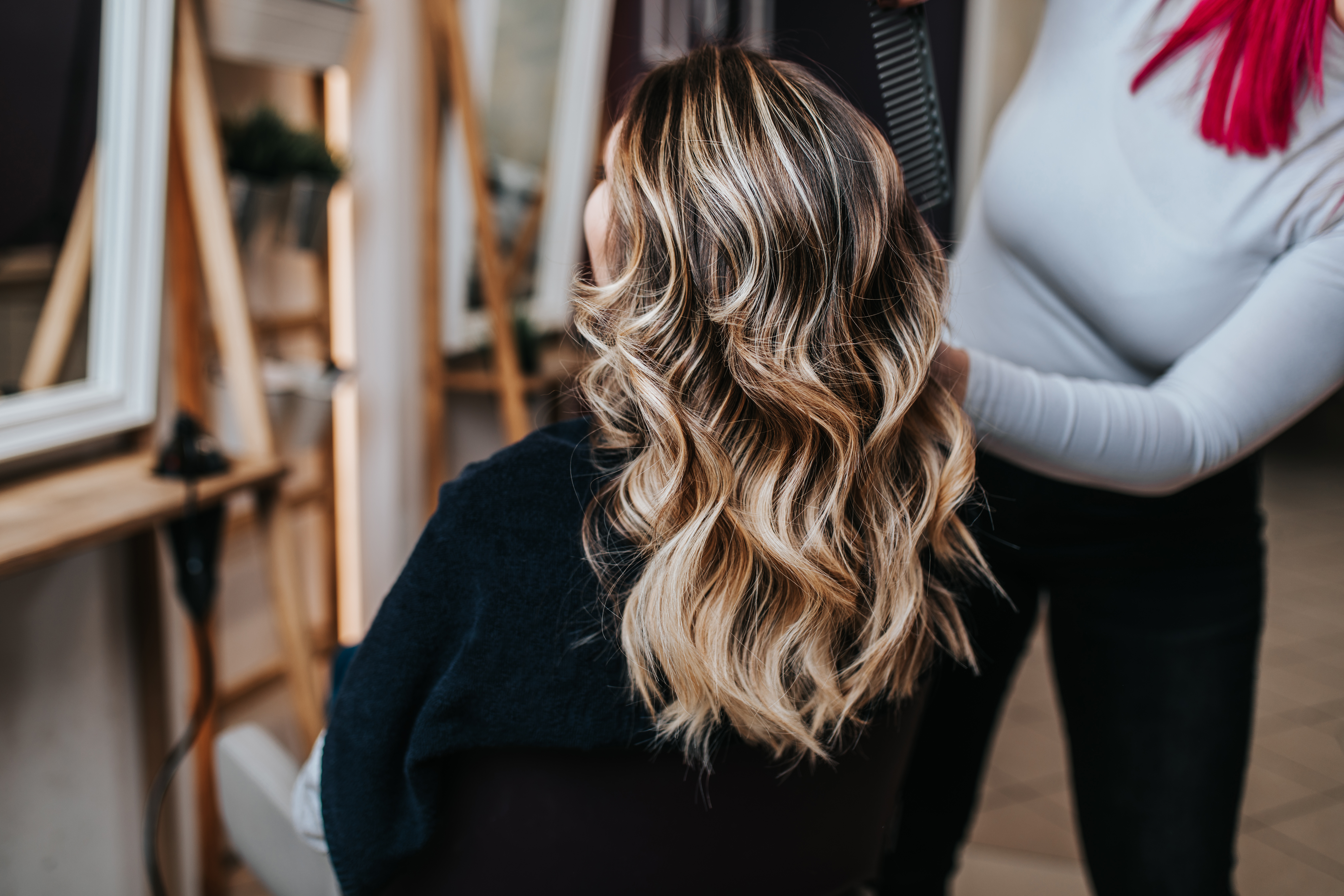 Una mujer recibiendo un tratamiento capilar por parte de un peluquero | Fuente: Shutterstock