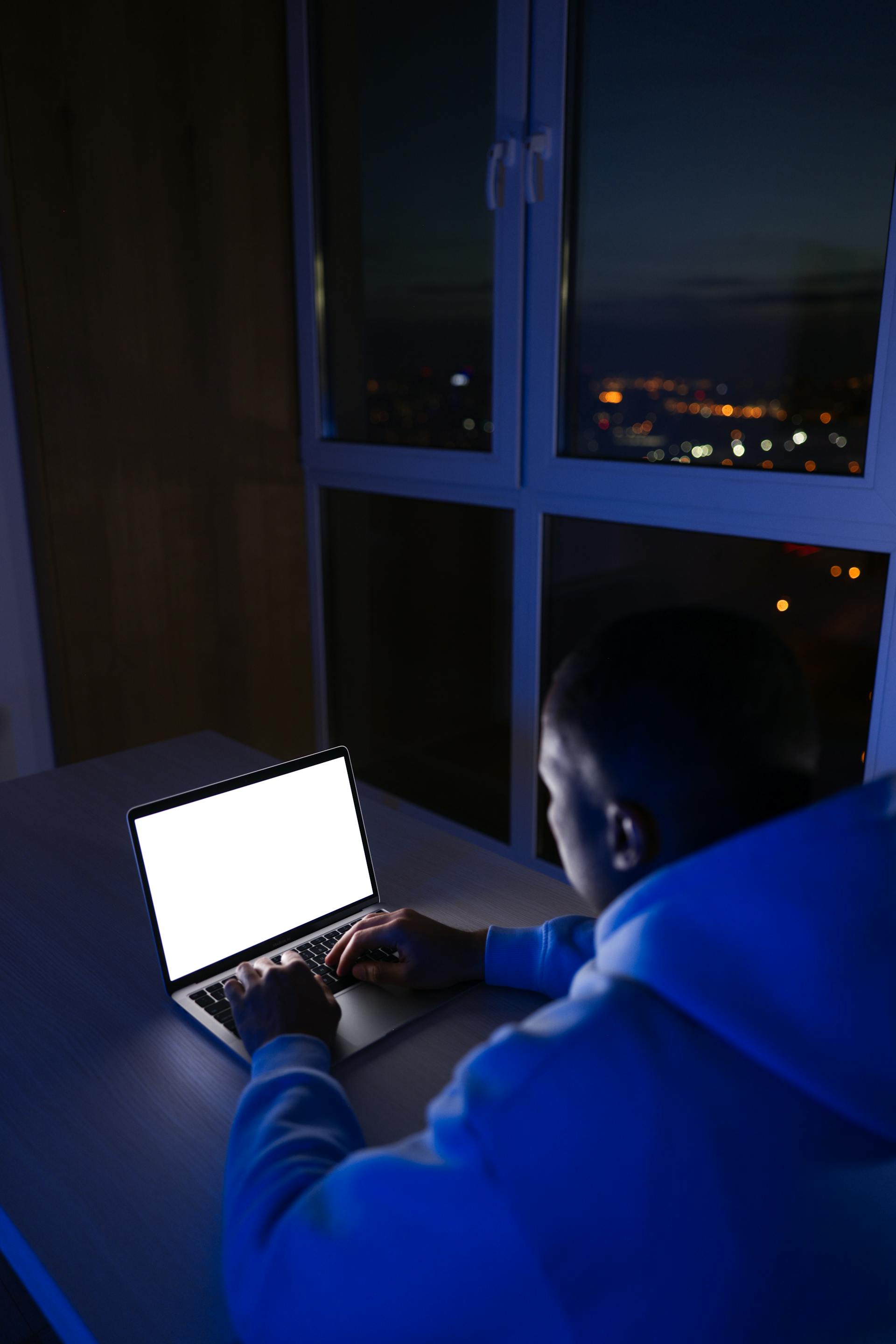 Un homme travaillant sur un ordinateur portable la nuit | Source : Pexels