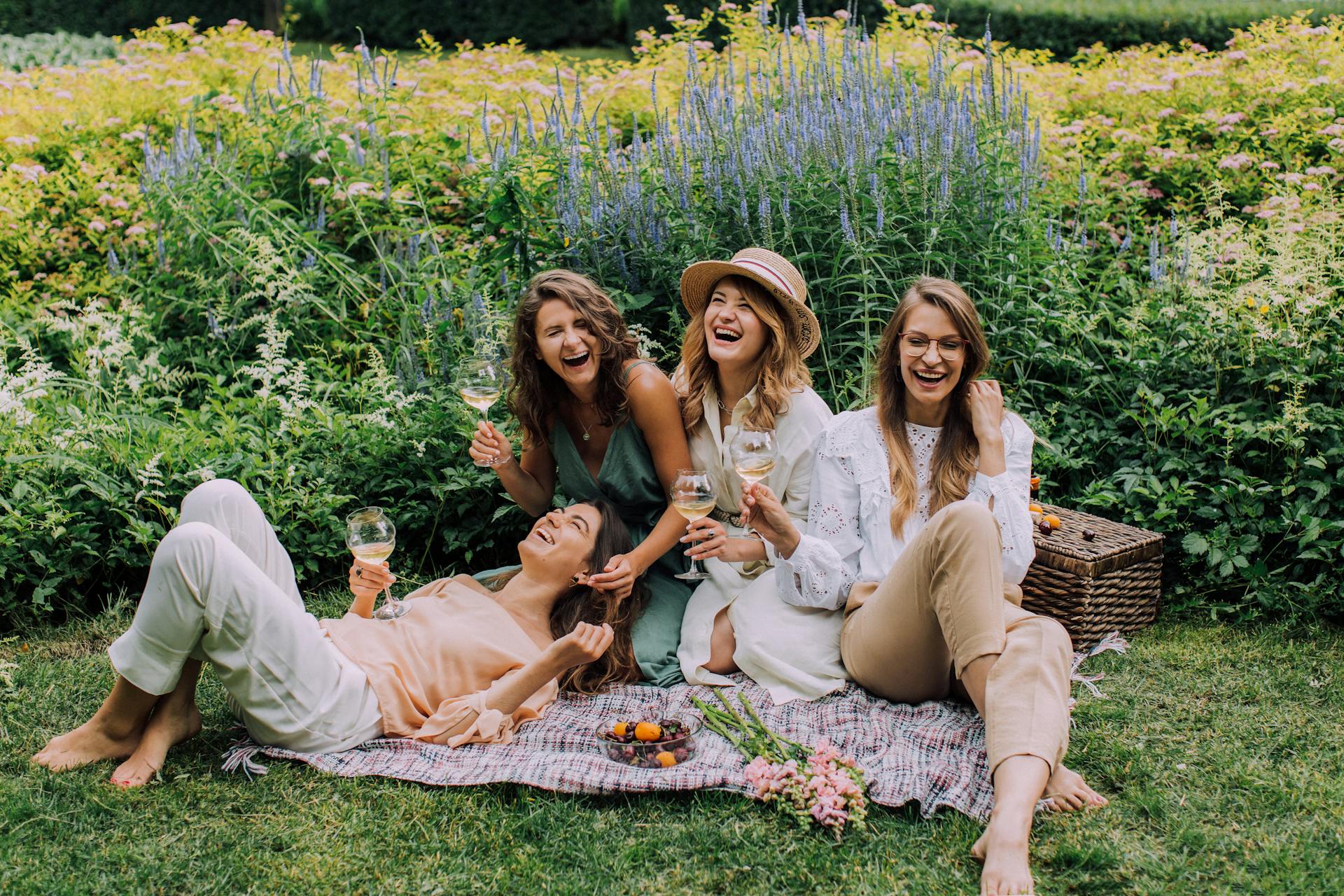 Des femmes assises sur l'herbe et dégustant leurs boissons | Source : Pexels