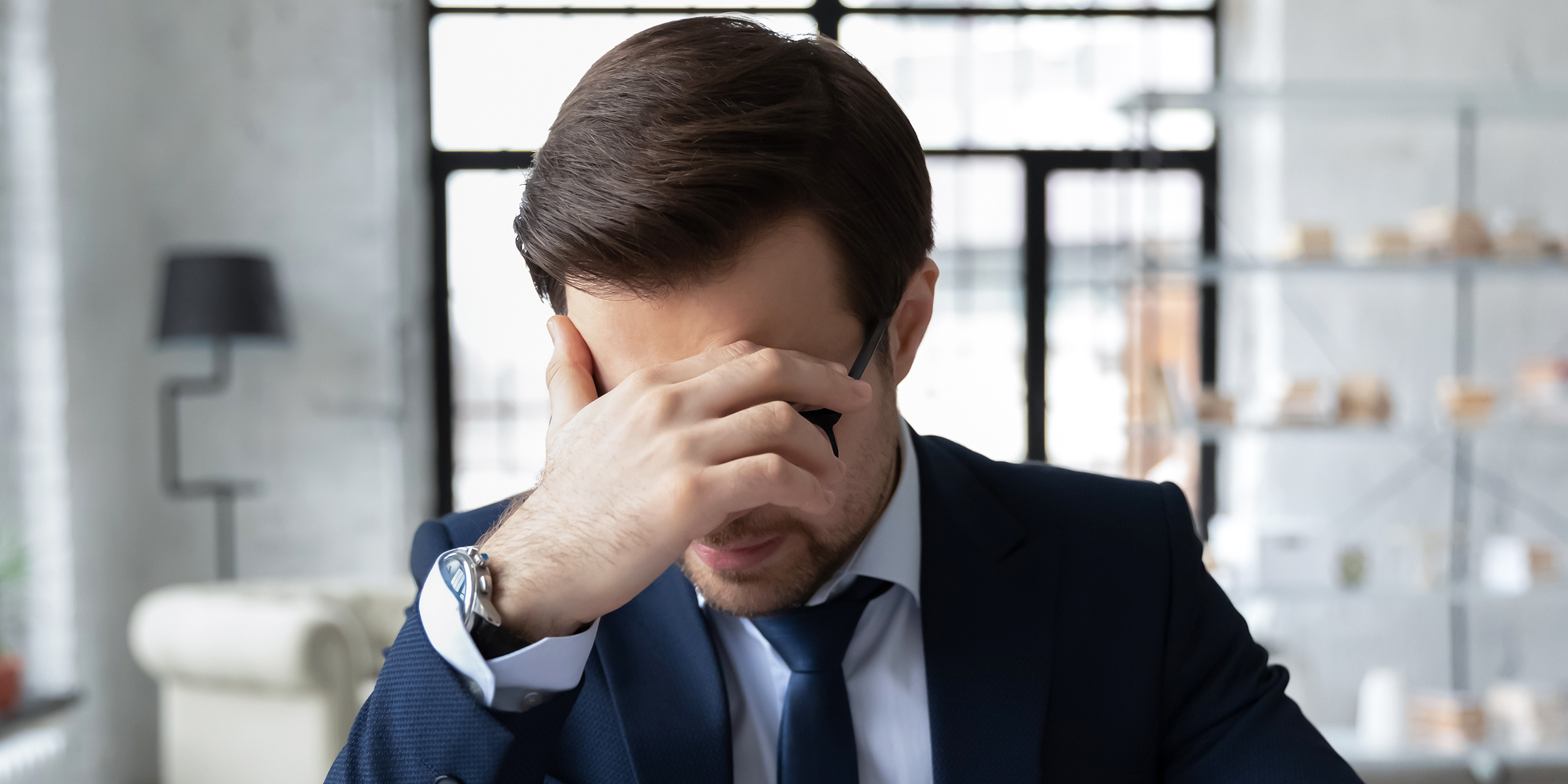 Un homme qui repose sa tête dans une main | Source : Shutterstock