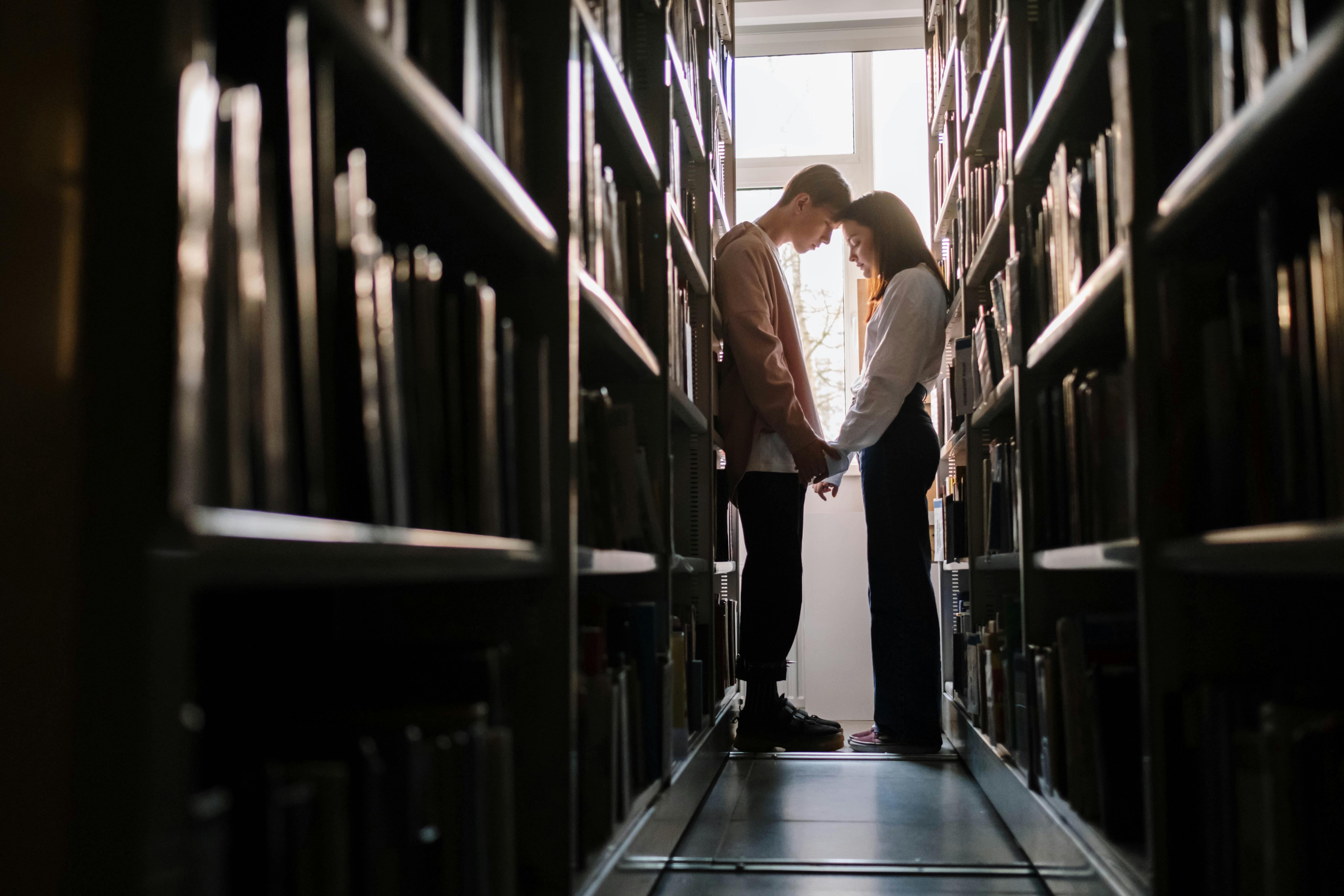 Un couple se rencontrant dans une bibliothèque | Source : Pexels