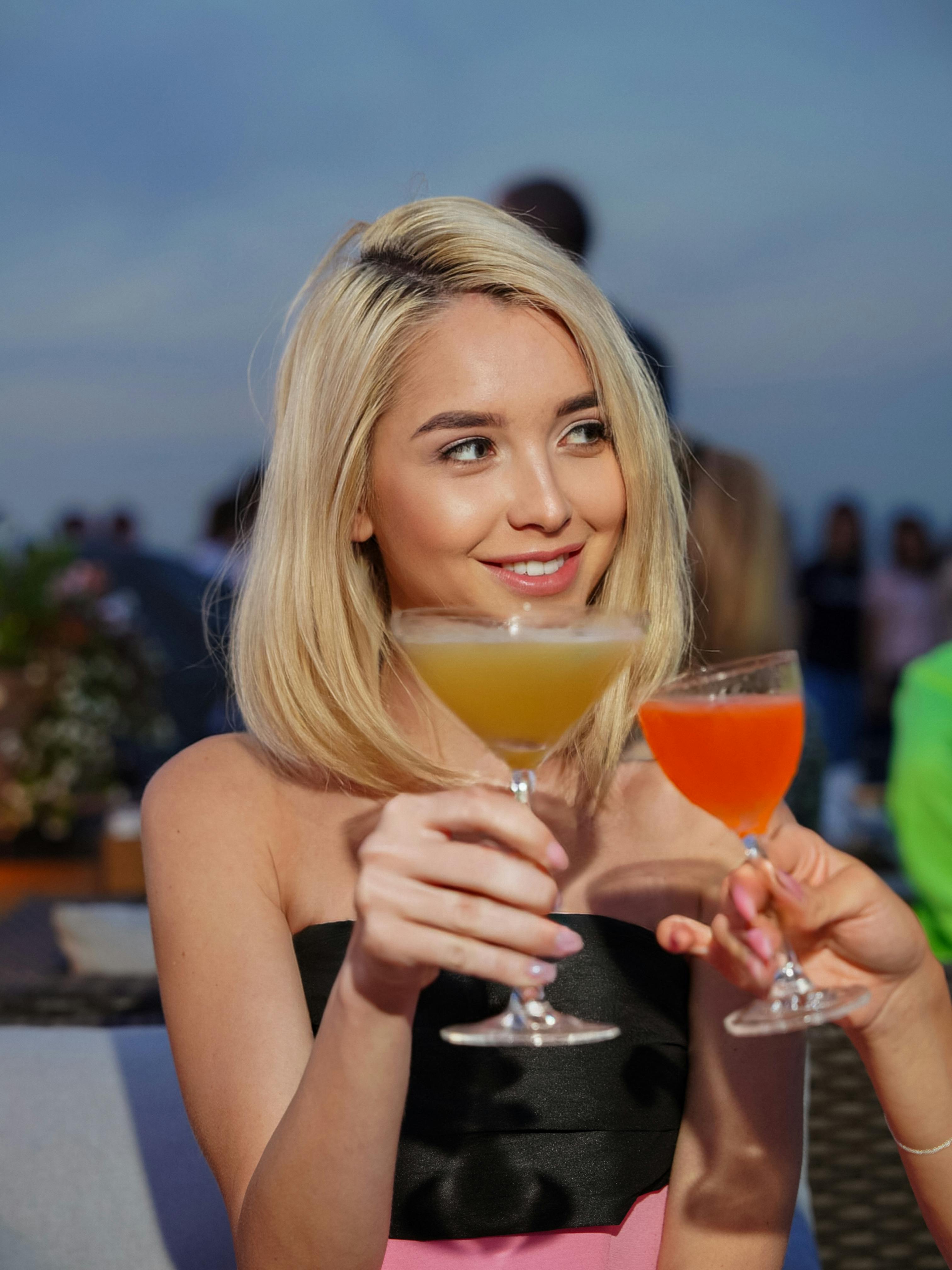 Blonde avec un cocktail pendant un toast | Source : Pexels