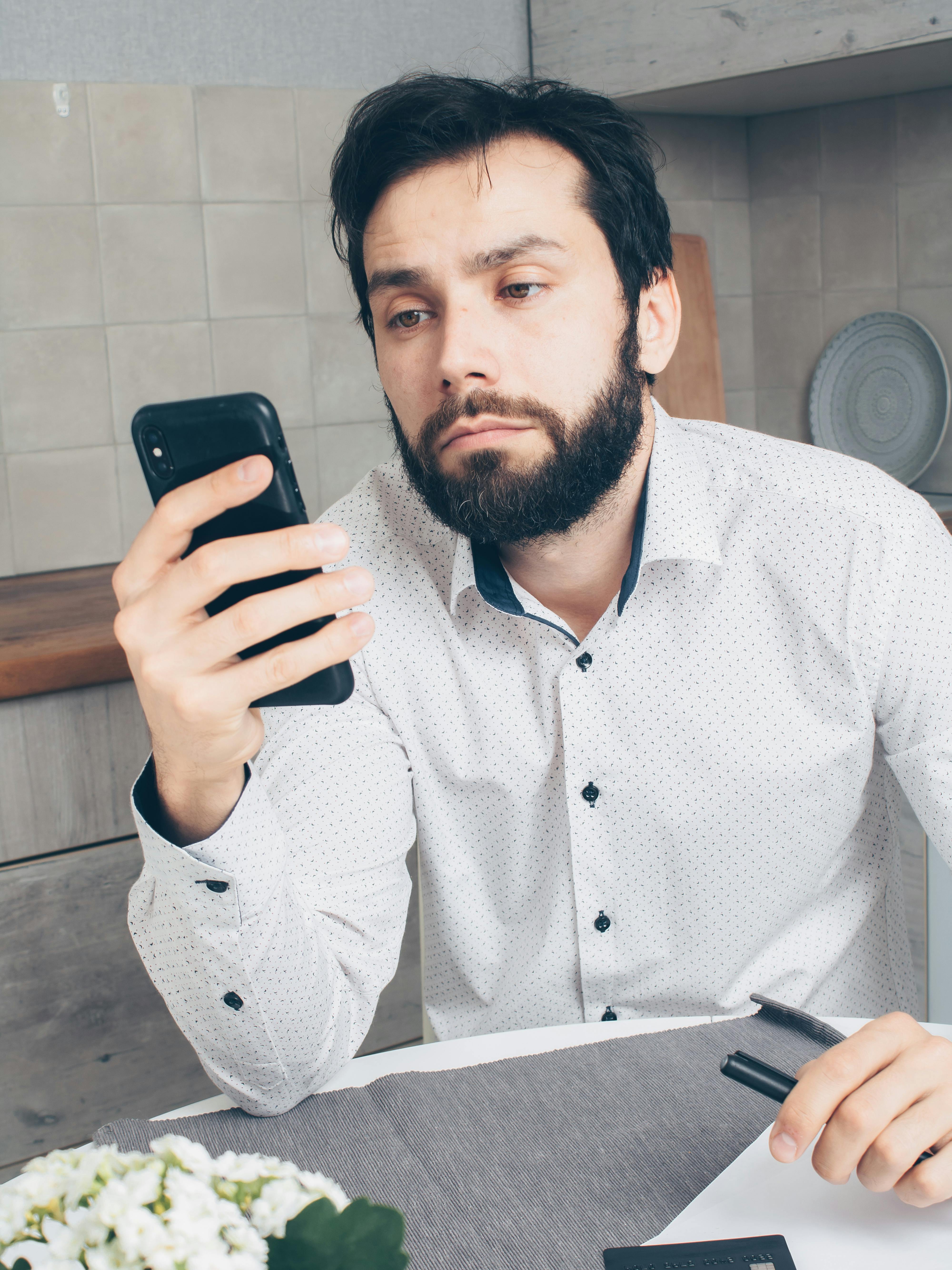 Un homme tenant un smartphone | Source : Pexels