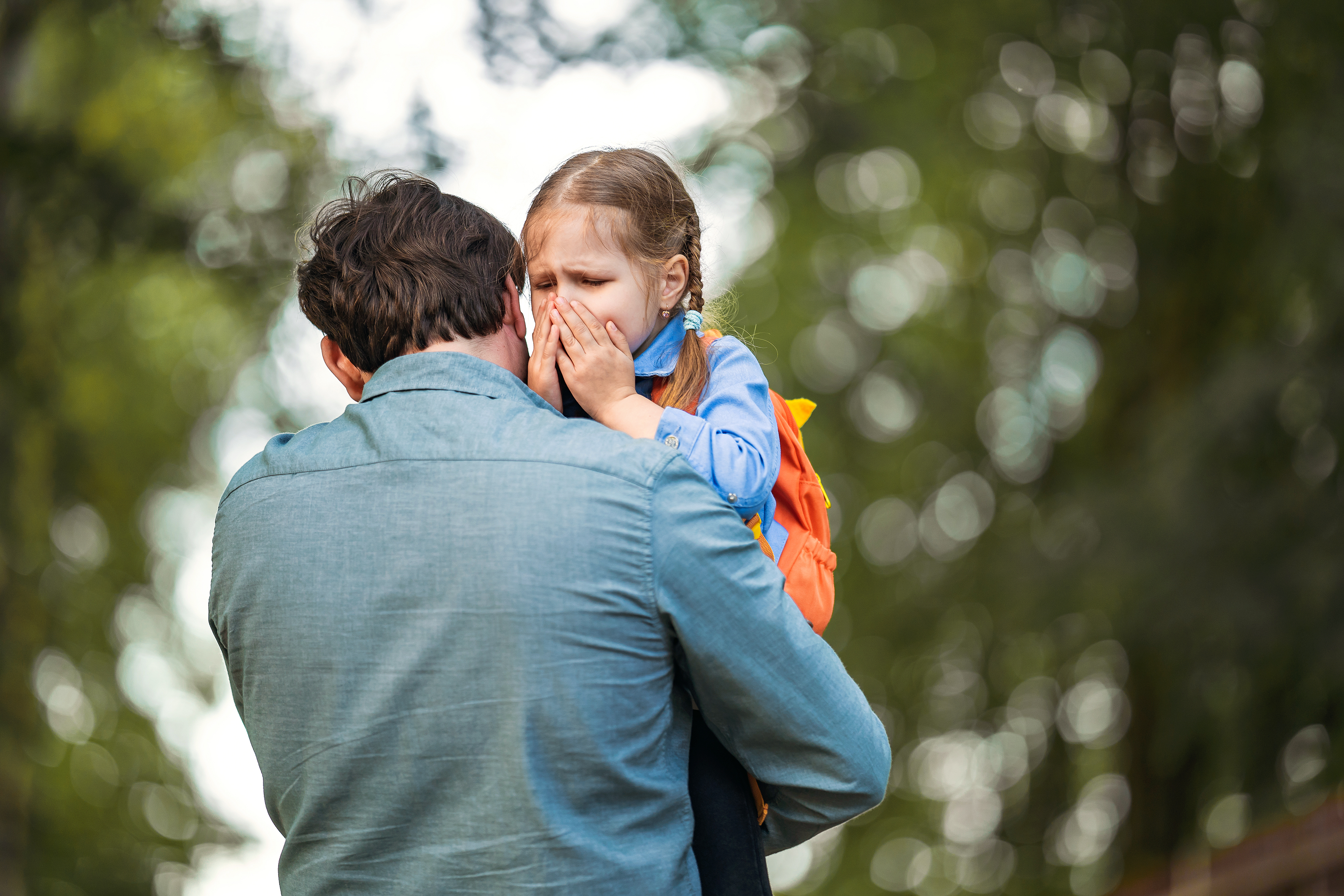 Un homme tenant une jeune fille en pleurs | Source : Shutterstock
