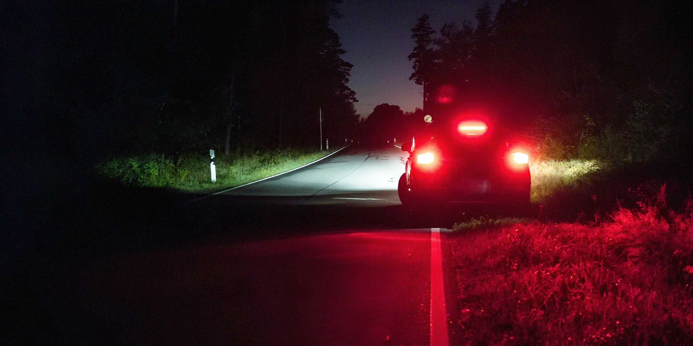 Voiture garée sur le bord de la route la nuit | Source : Getty Images