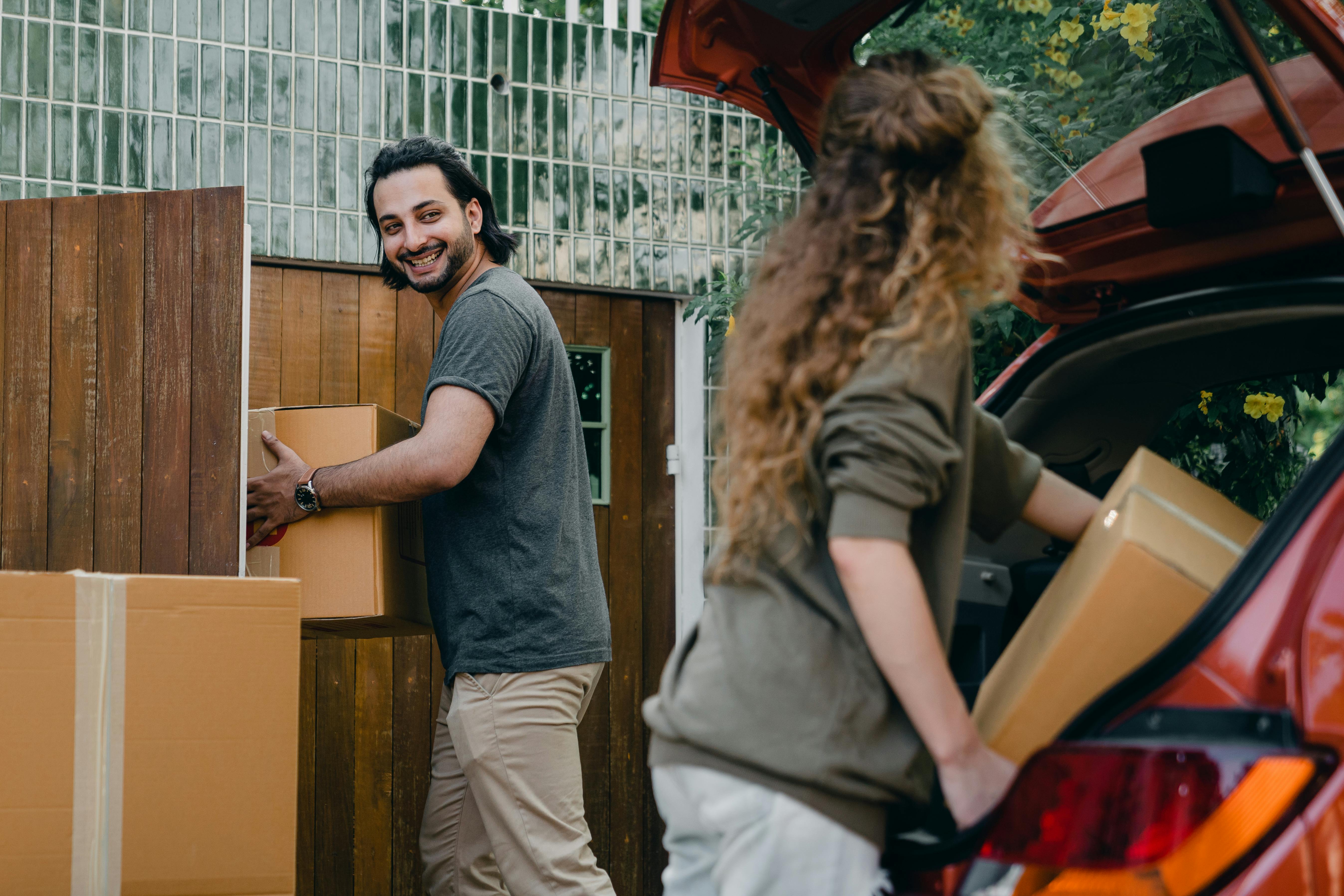 Un couple décharge des cartons d'une voiture | Source : Pexels