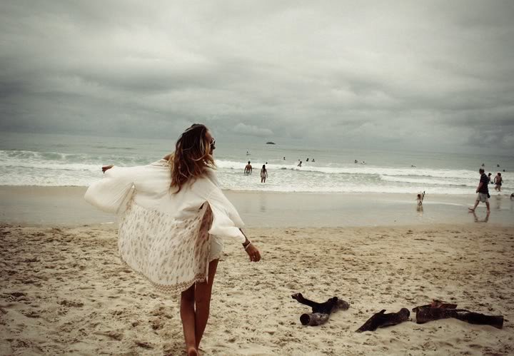 Une femme portant un poncho sur la plage. l Source:  Flickr
