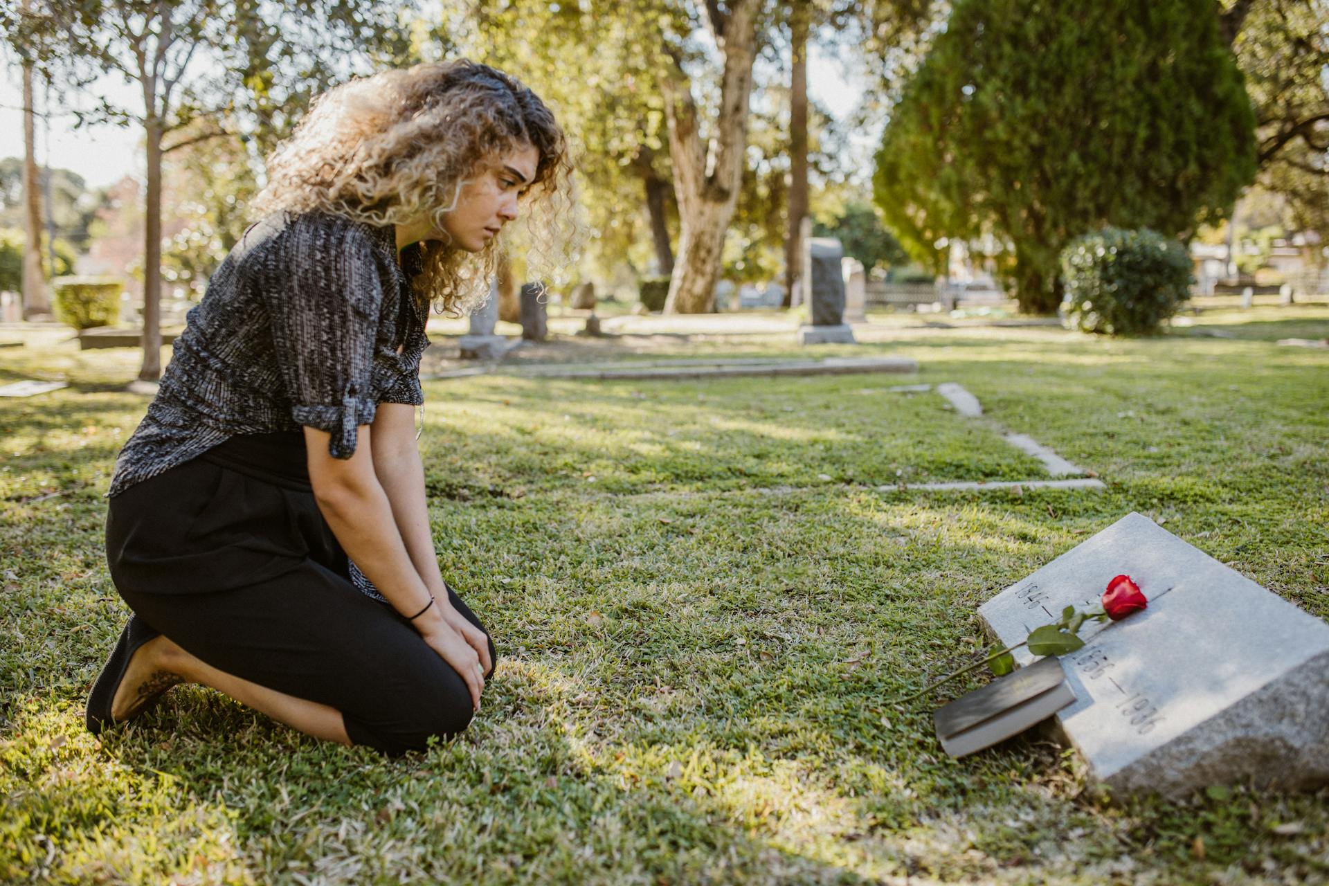 Une femme assise près d'une tombe | Source : Pexels