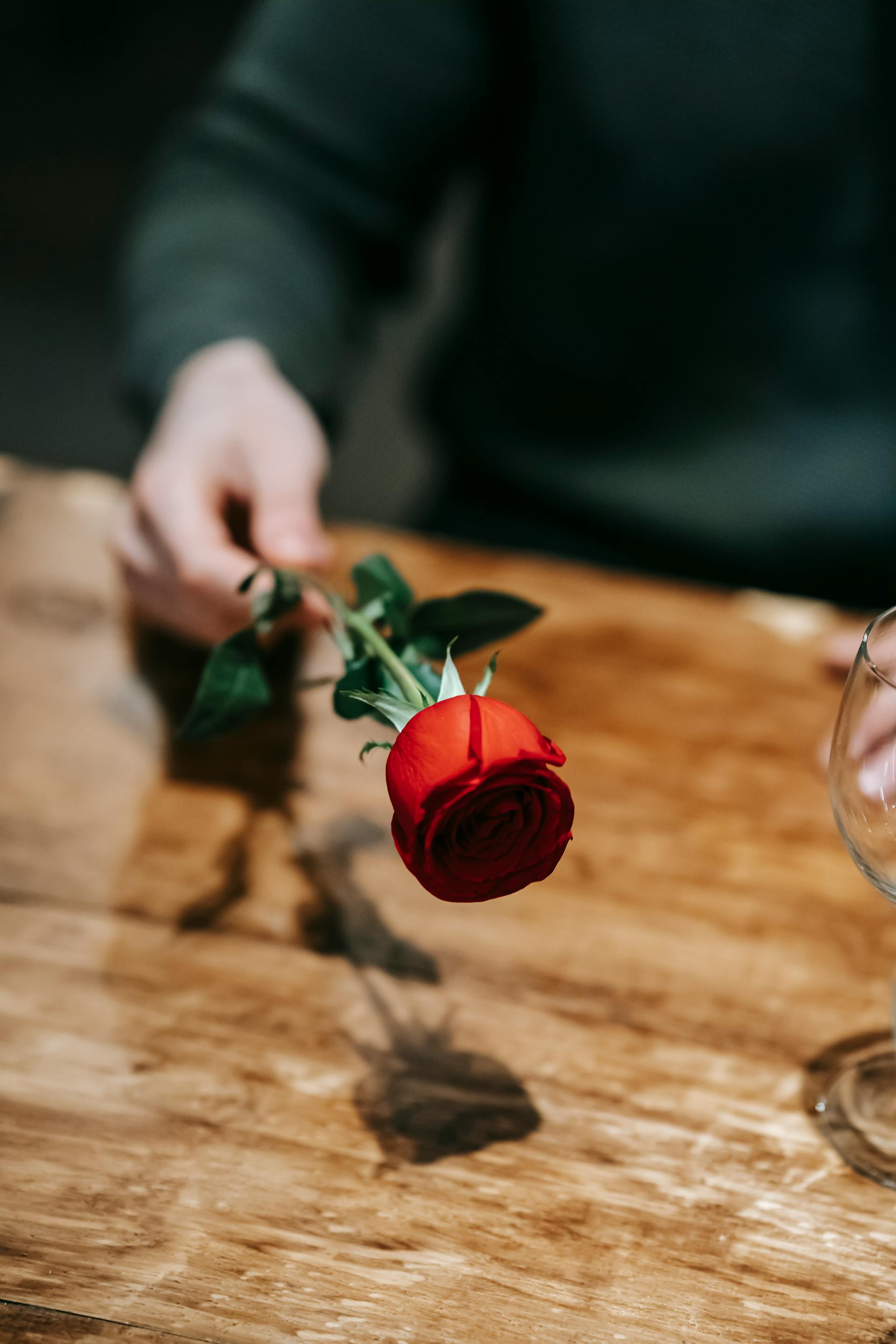 Un homme tenant une rose rouge | Source : Pexels