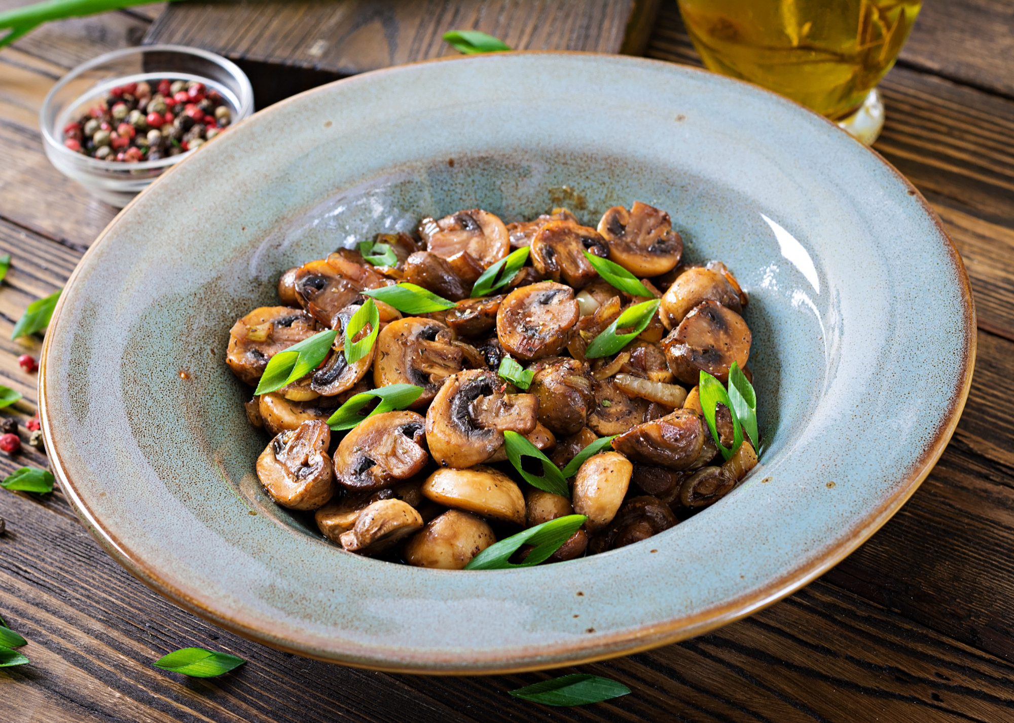 Une assiette de champignons cuits au four avec de la sauce soja et des herbes | Source : Freepik