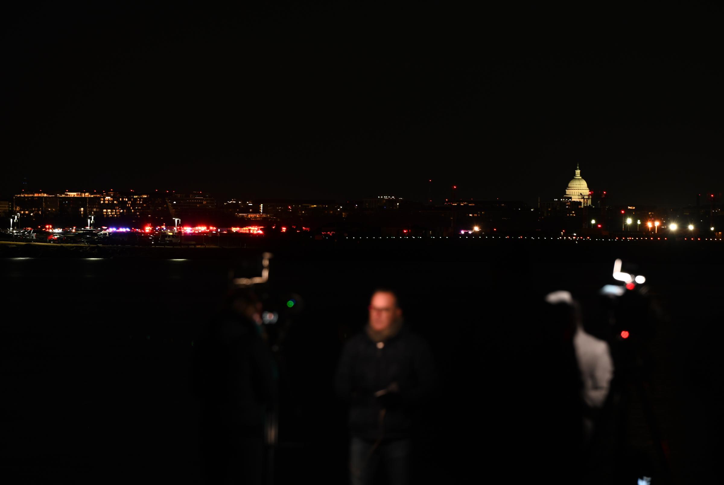 Une vue du Capitole américain et des journalistes près de l'endroit où l'accident s'est produit à Washington, D.C., le 30 janvier 2025. | Source : Getty Images