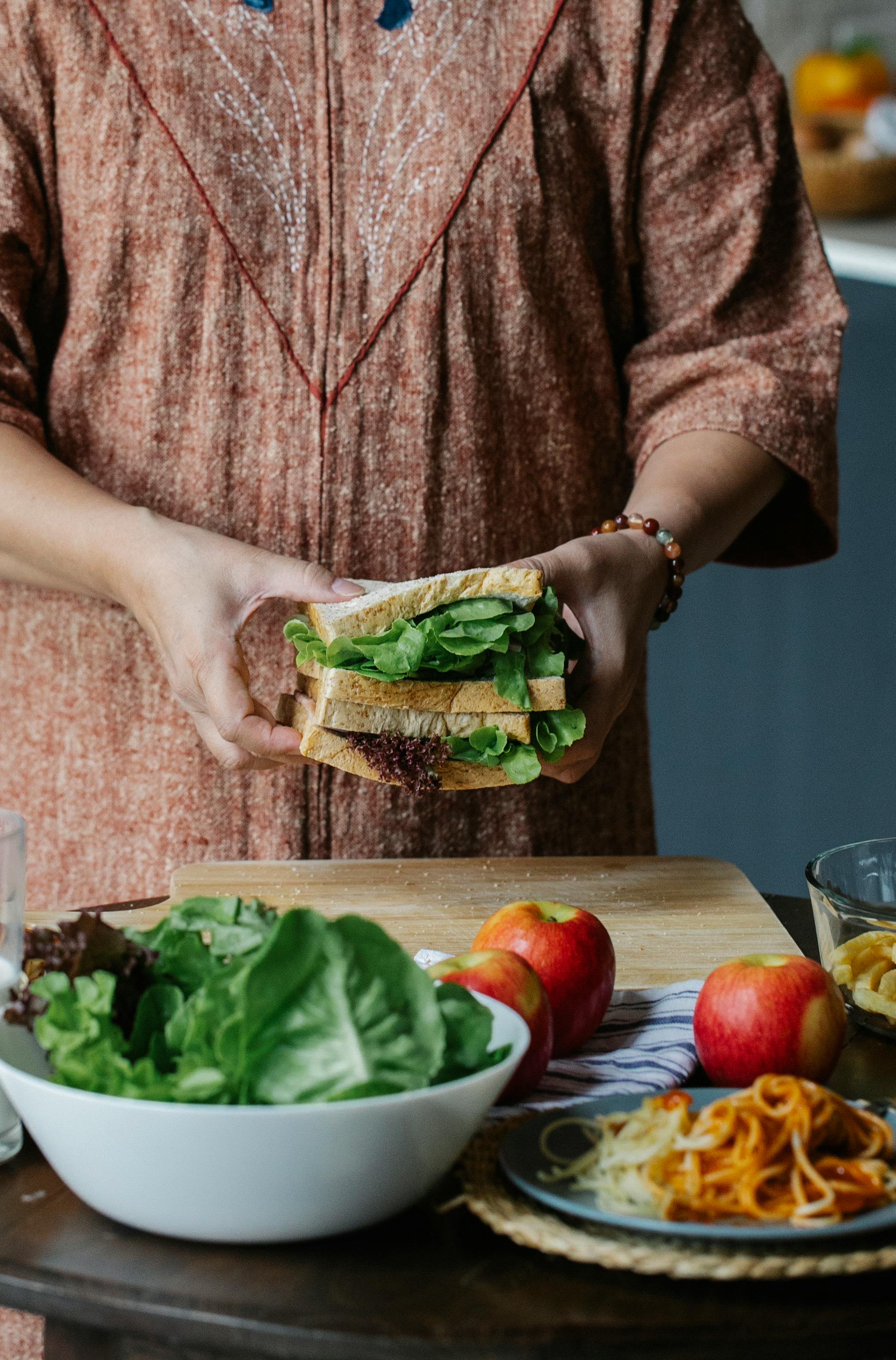 Gros plan sur une femme qui prépare un sandwich dans la cuisine | Source : Pexels