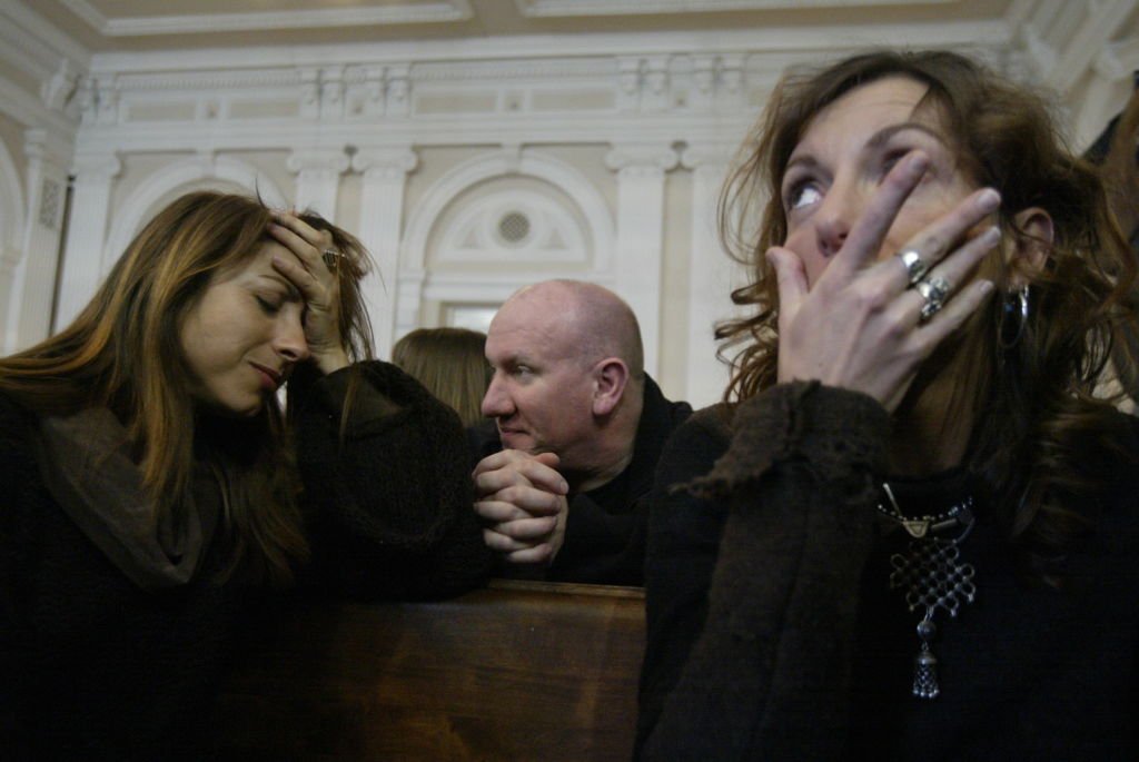 Anne CANTAT, la soeur du chanteur et Kristina RADY, son épouse, toutes deux très émues assises dans le tribunal avec Denis BARTHE le batteur de NOIR DESIR. | photo : Getty Images