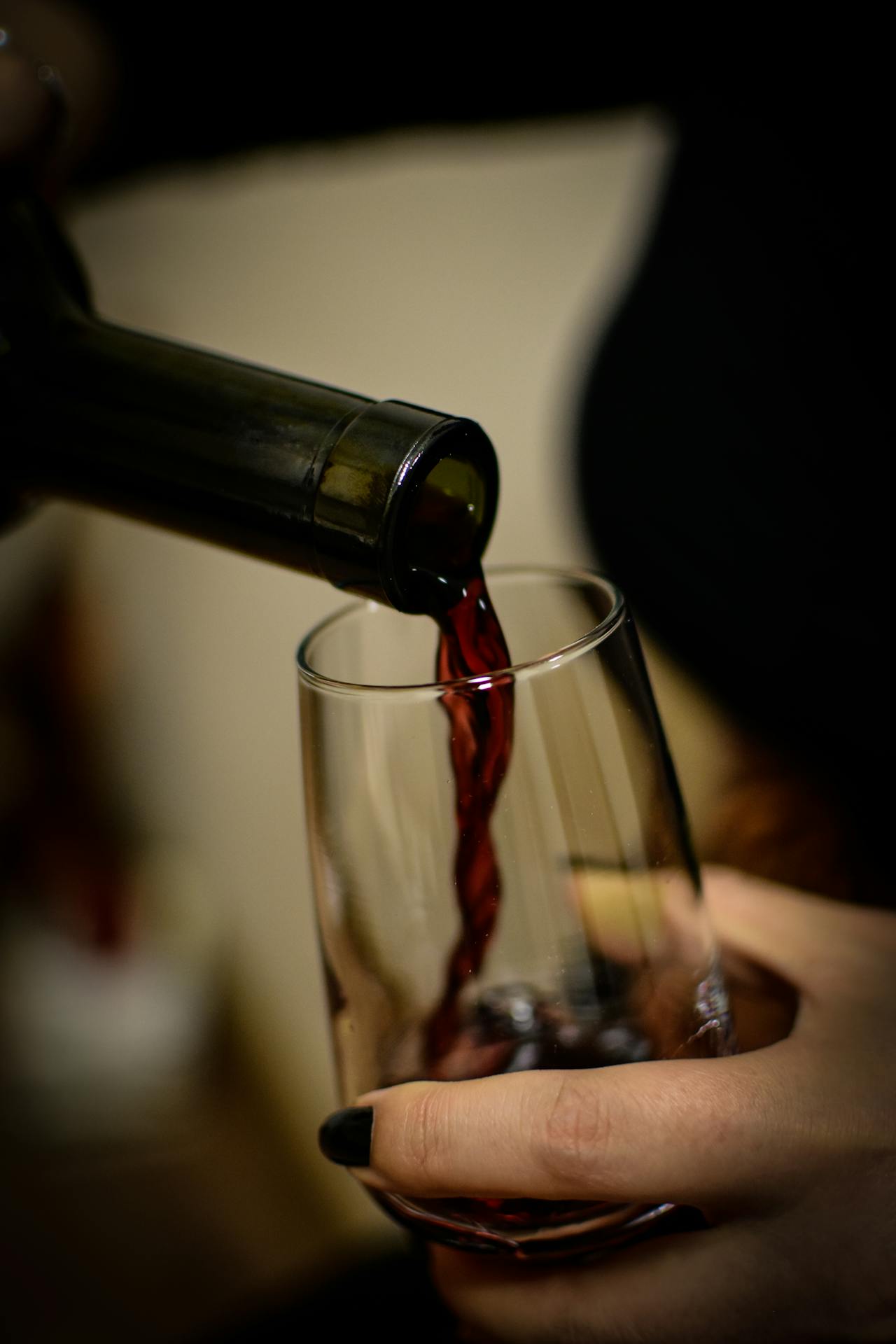 Une femme versant du vin dans un verre | Source : Pexels