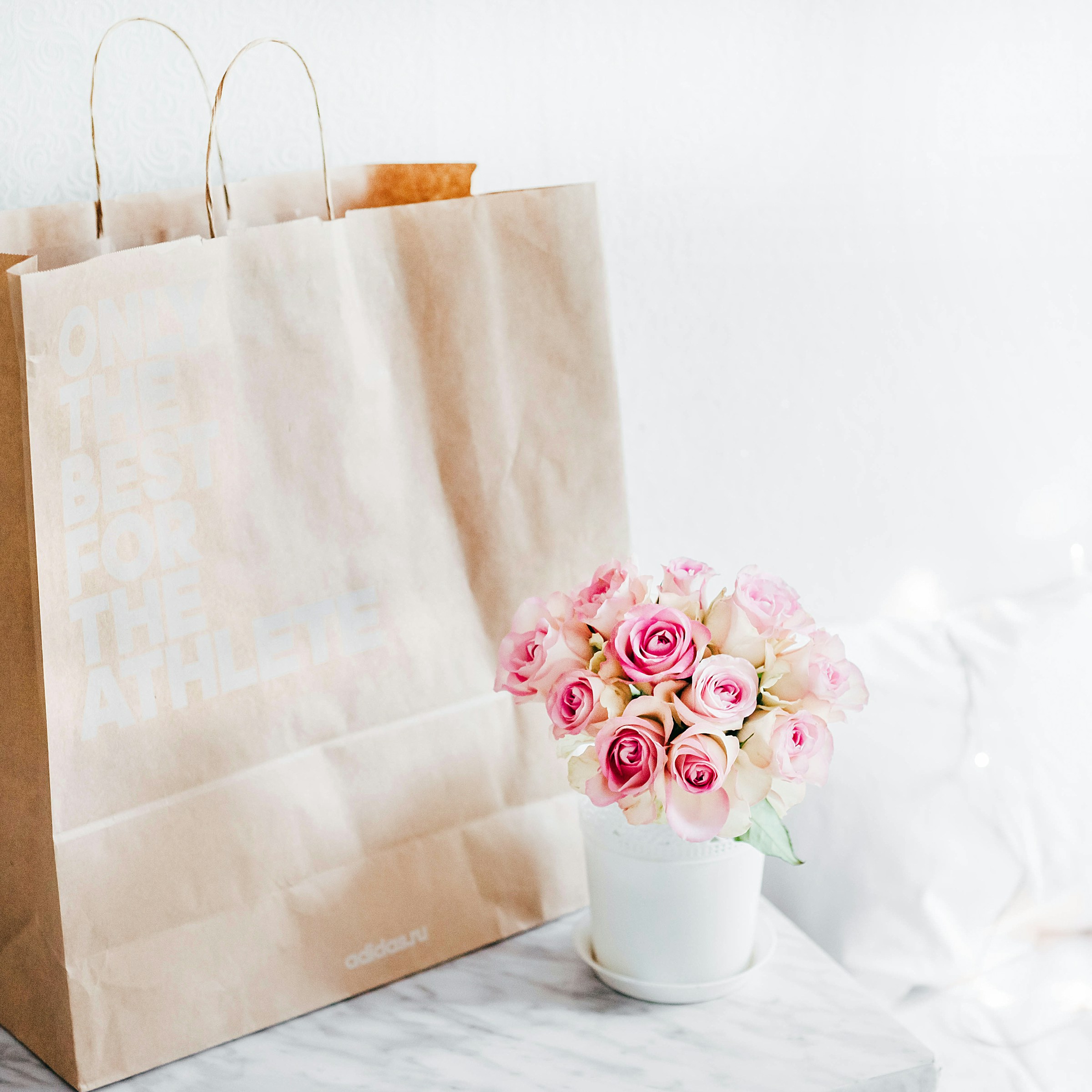Un bouquet de roses roses et un sac brun | Source : Unsplash