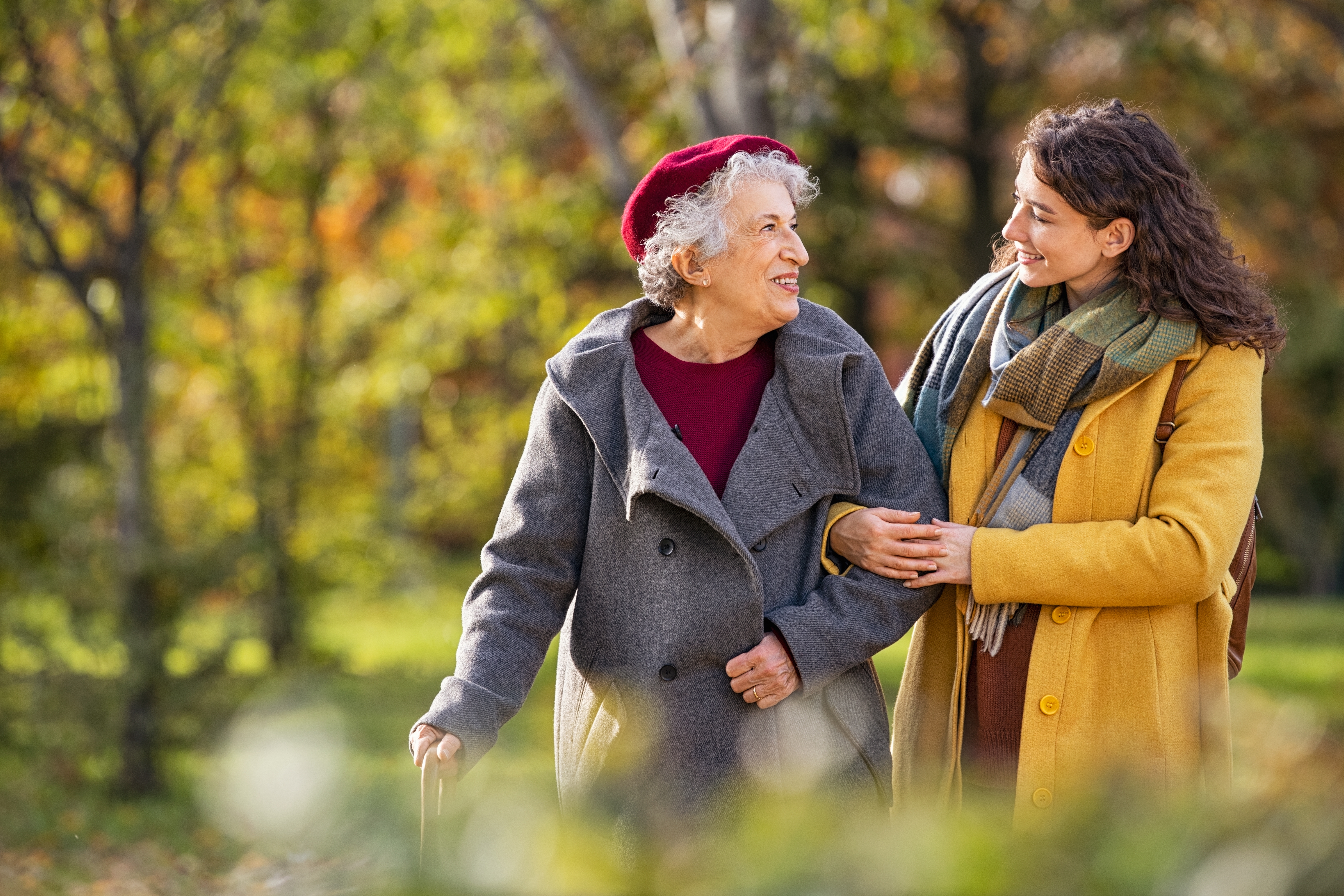 Une femme et sa grand-mère marchant bras dessus bras dessous | Source : Shutterstock