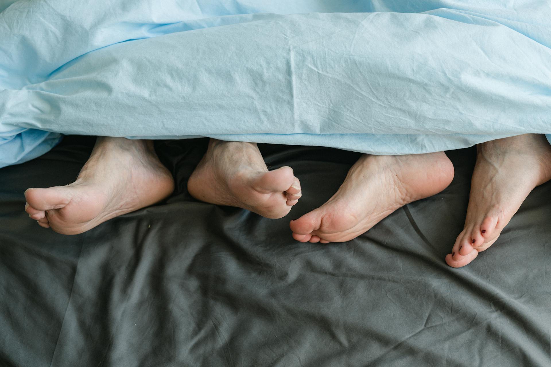 Un homme allongé à côté d'une femme au lit | Source : Pexels