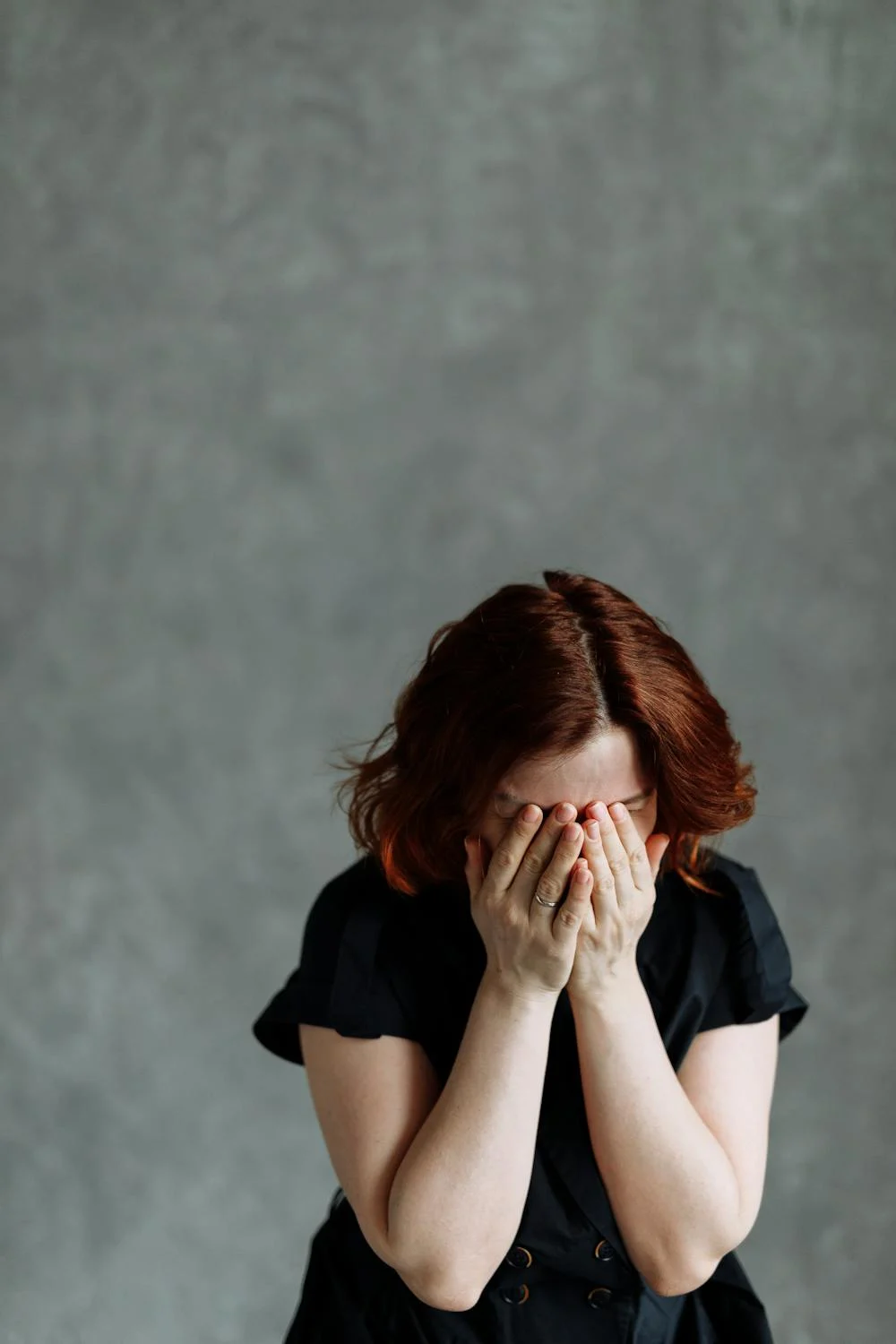 Une femme en pleurs qui se couvre le visage avec ses mains | Source : Pexels