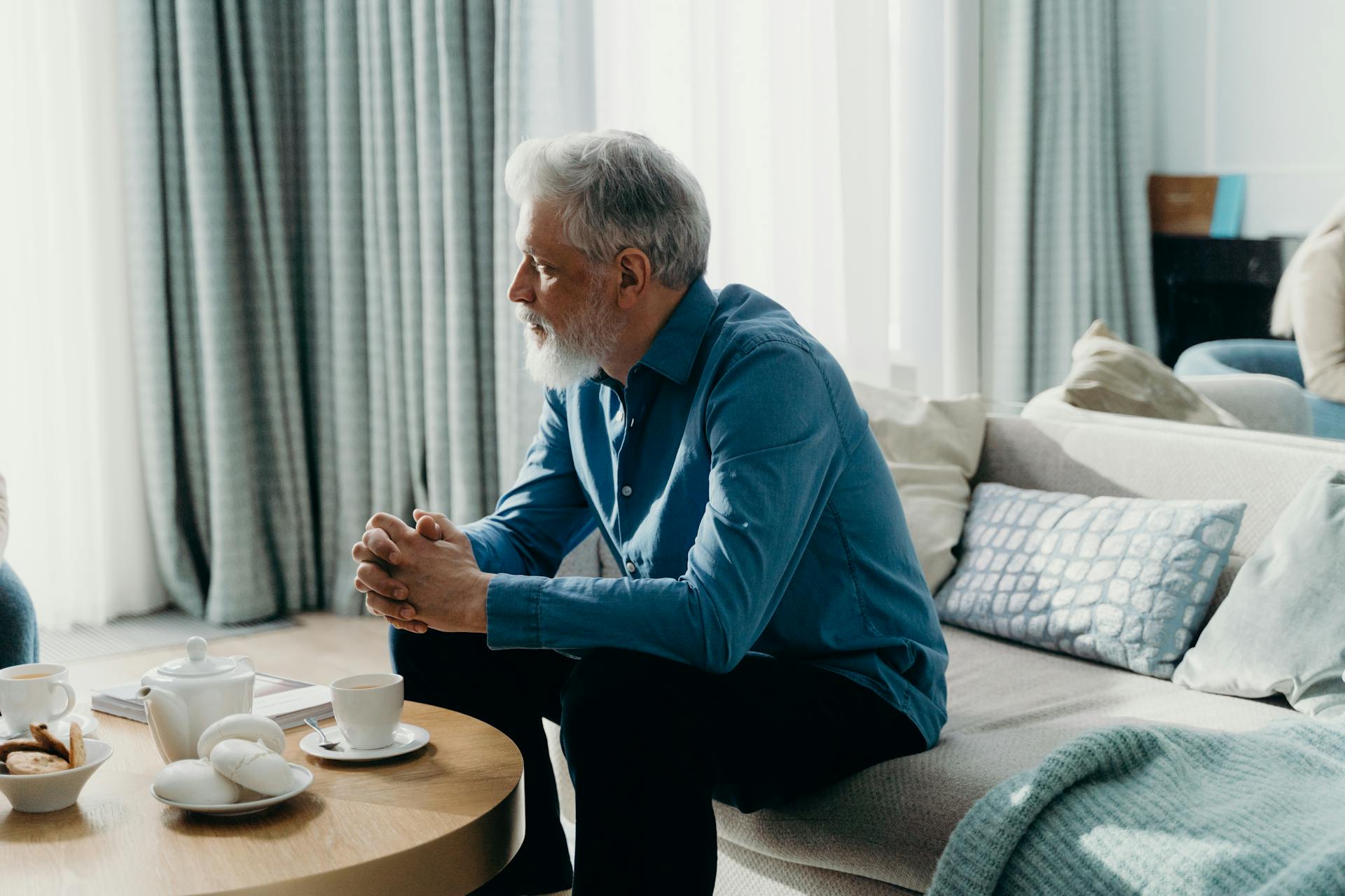 Un homme âgé en chemise bleue assis sur le canapé | Source : Pexels