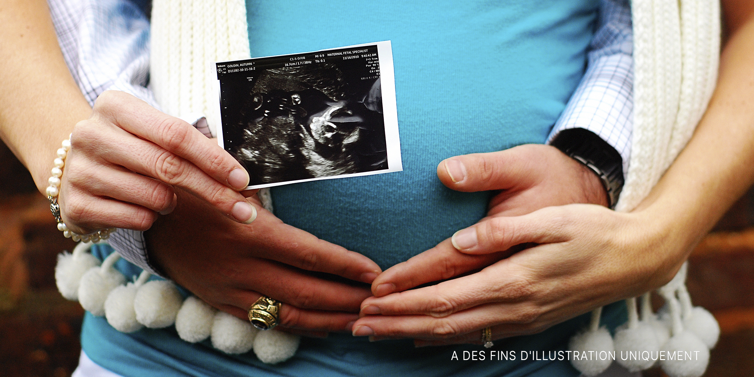 Un couple tenant un scanner de grossesse | Source : Shutterstock