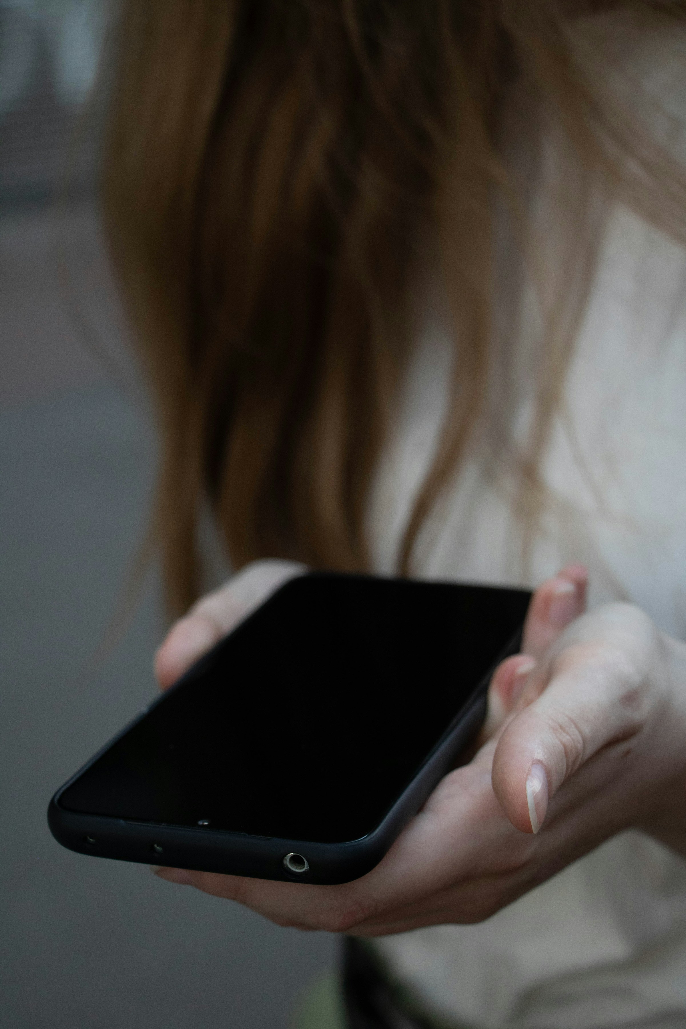 Une jeune femme tenant son téléphone | Source : Unsplash