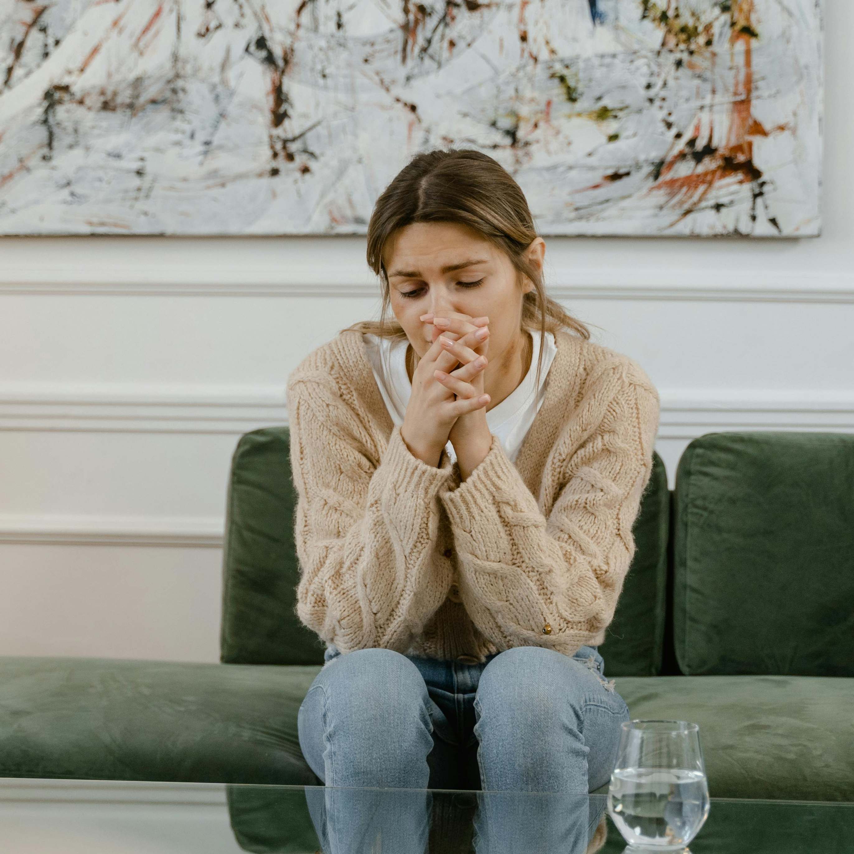 Une femme à l'air contrarié assise sur un canapé | Source : Pexels