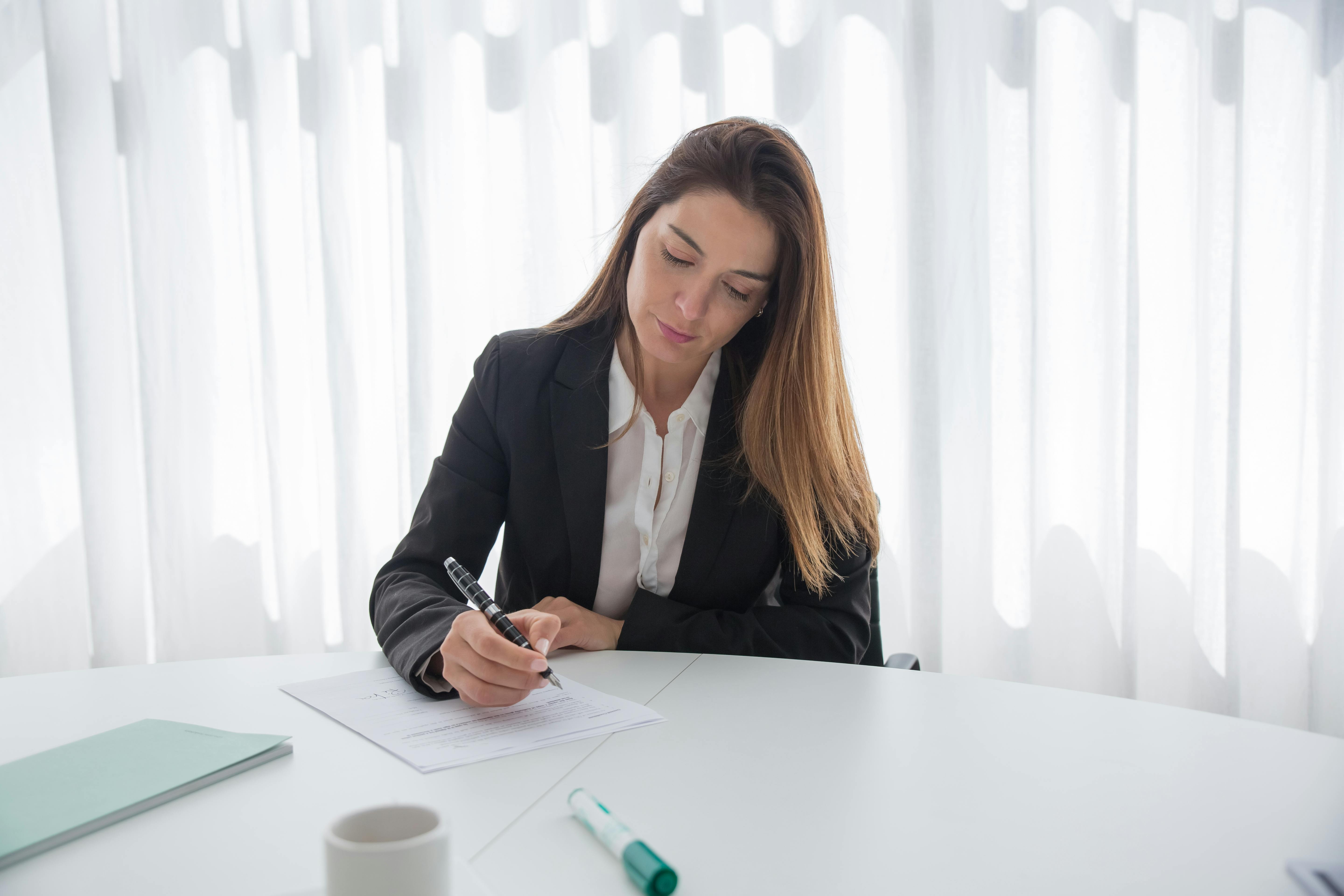 Femme signant des documents | Source : Pexels