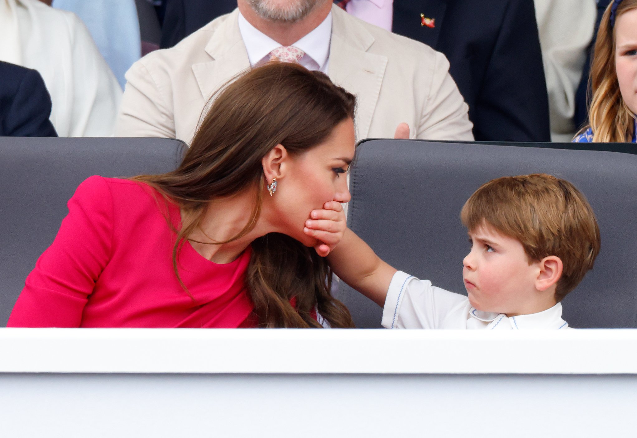 Le prince Louis de Cambridge couvre la bouche de sa mère Catherine, duchesse de Cambridge, avec sa main alors qu'ils assistent au Platinum Pageant sur The Mall le 5 juin 2022 à Londres, en Angleterre. | Source : Getty Images