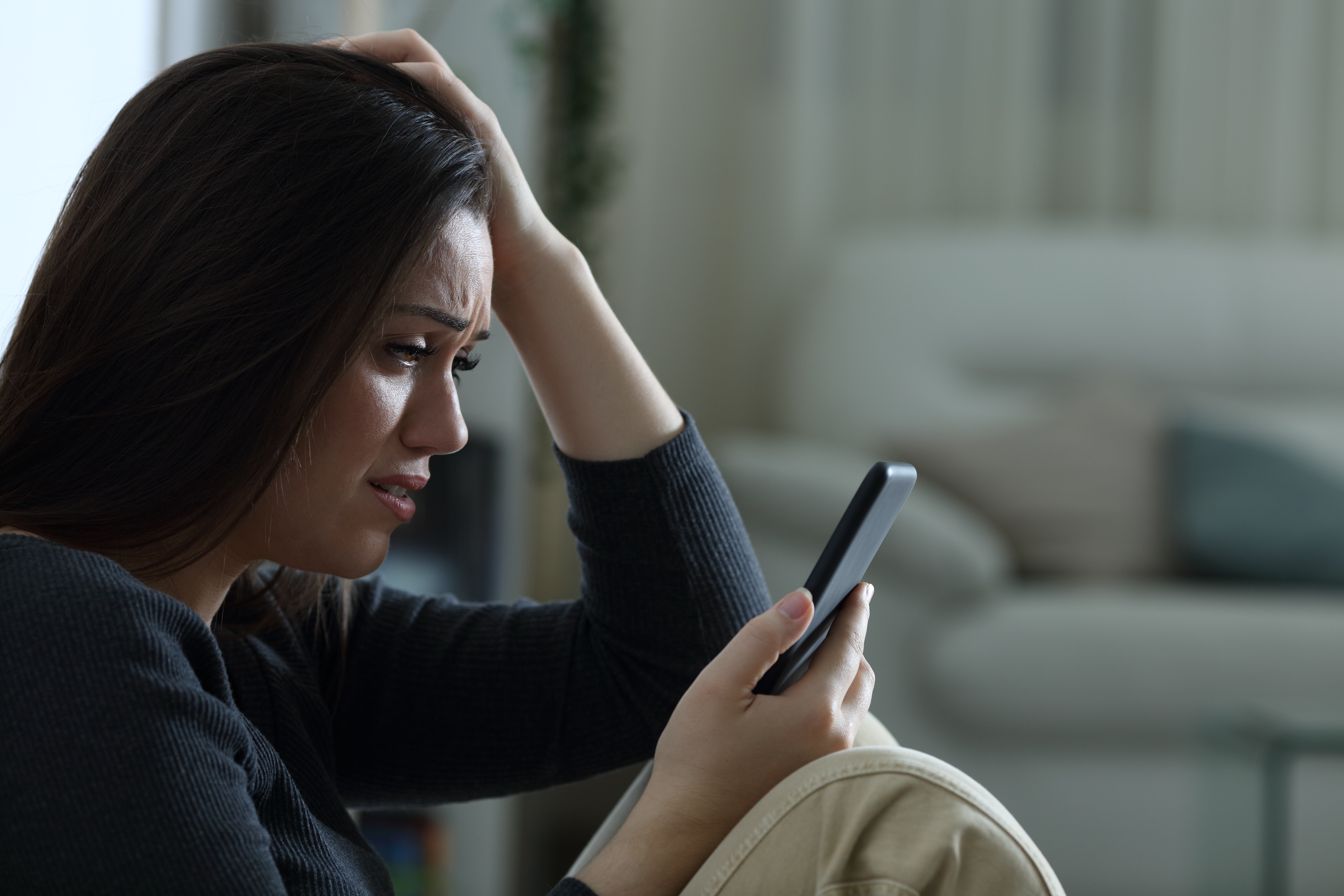 Une femme bouleversée qui regarde son téléphone | Source : Shutterstock
