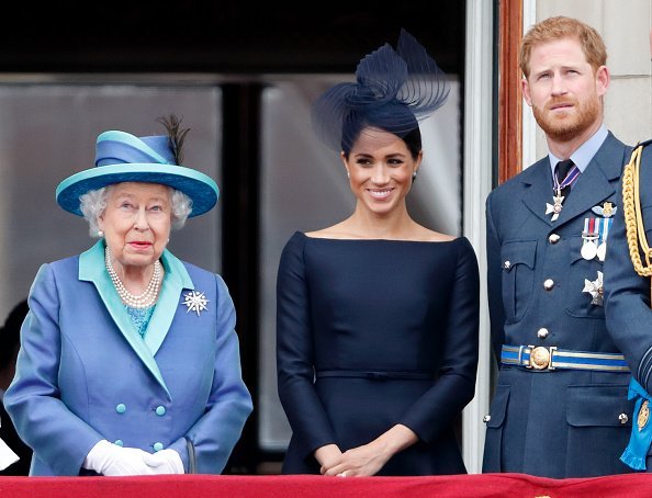 La reine Elizabeth II, Meghan, et le prince Harry regardent un défilé aérien. | Photo : Getty Images