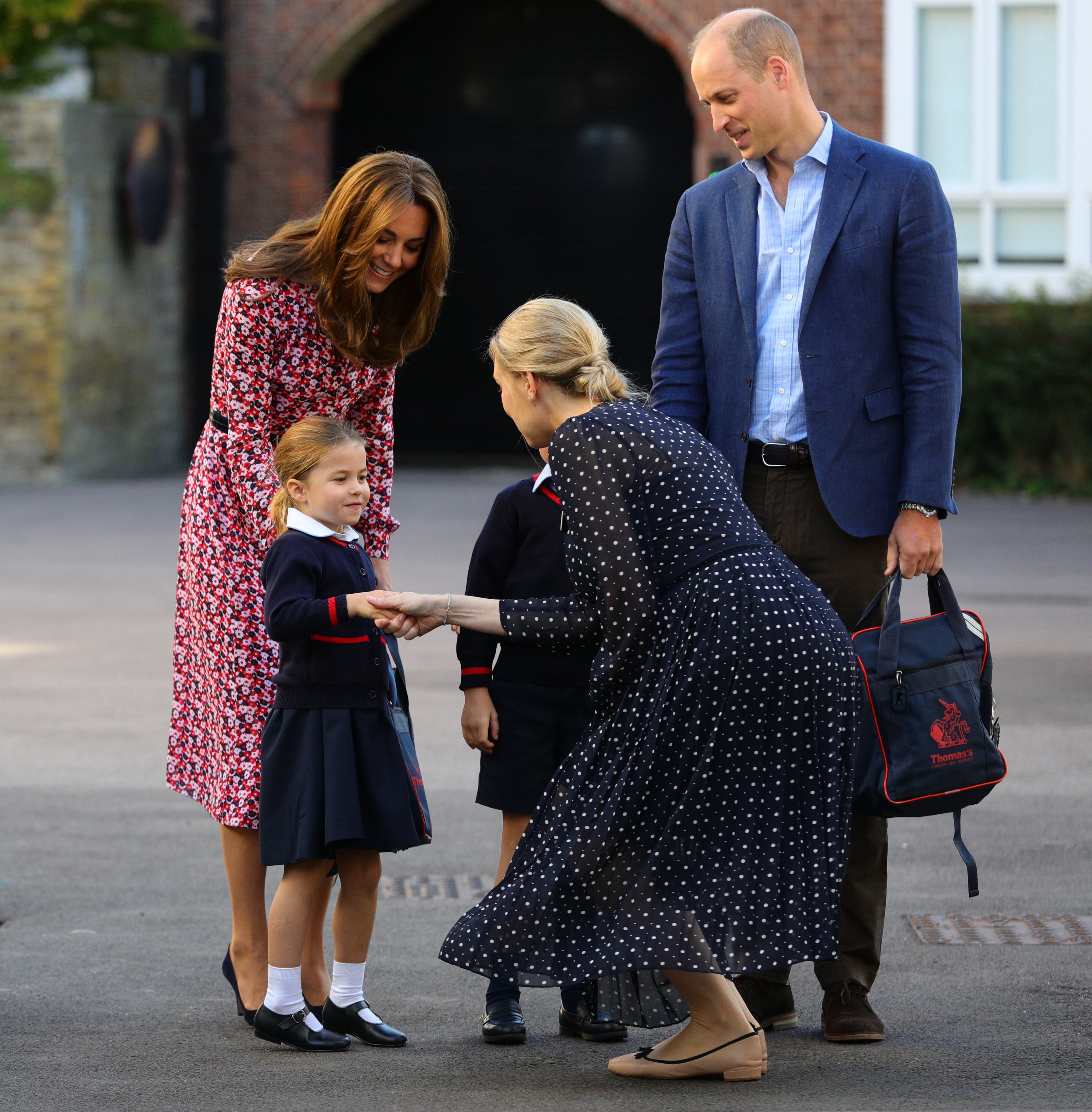 Helen Haslem salue la princesse Charlotte alors qu'elle arrive pour son premier jour d'école, ainsi que ses parents Kate Middleton et le prince William, à Thomas's Battersea à Londres, le 5 septembre 2019, à Londres, en Angleterre. | Source : Getty Images