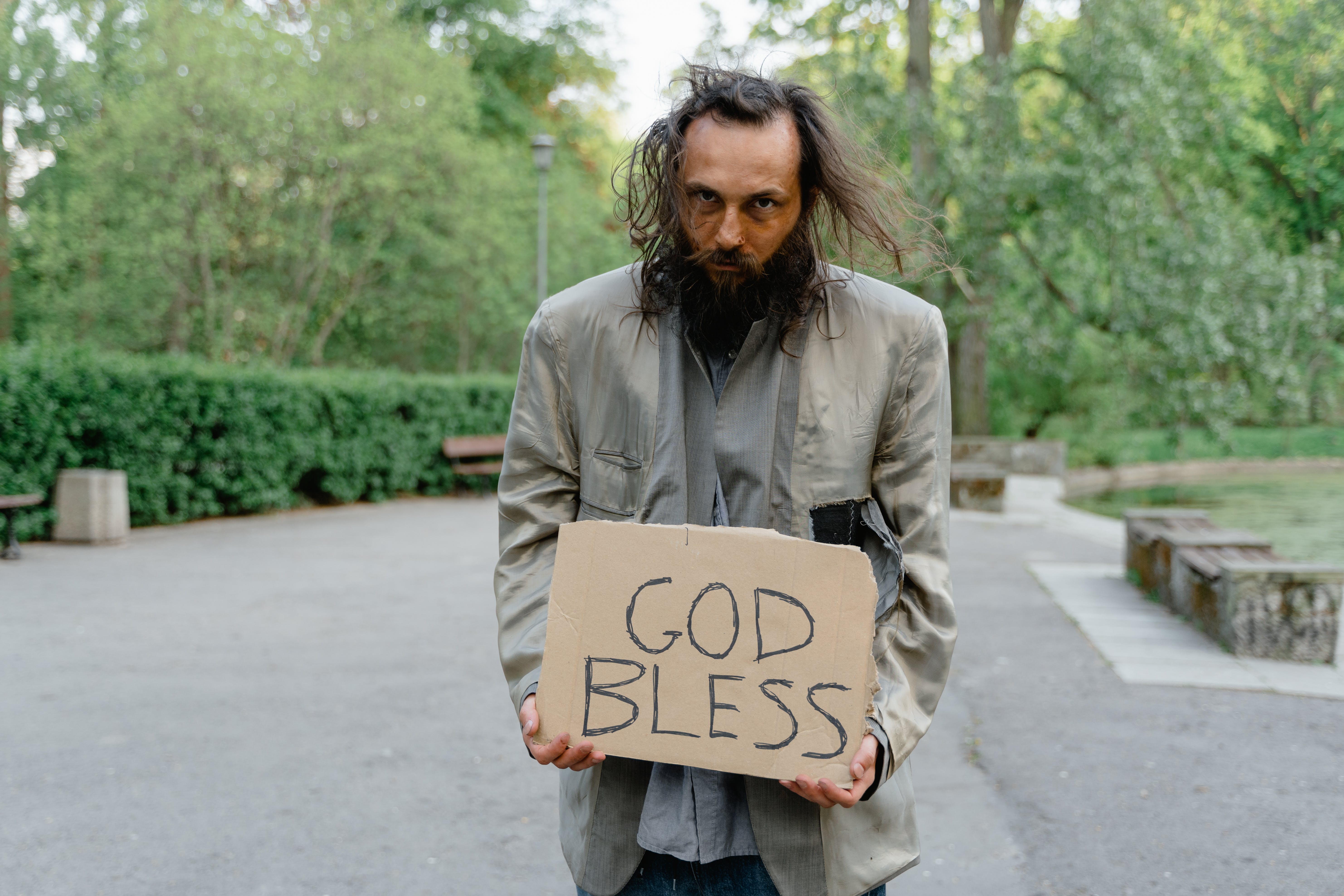 Un sans-abri debout avec une pancarte sur la route | Source : Pexels