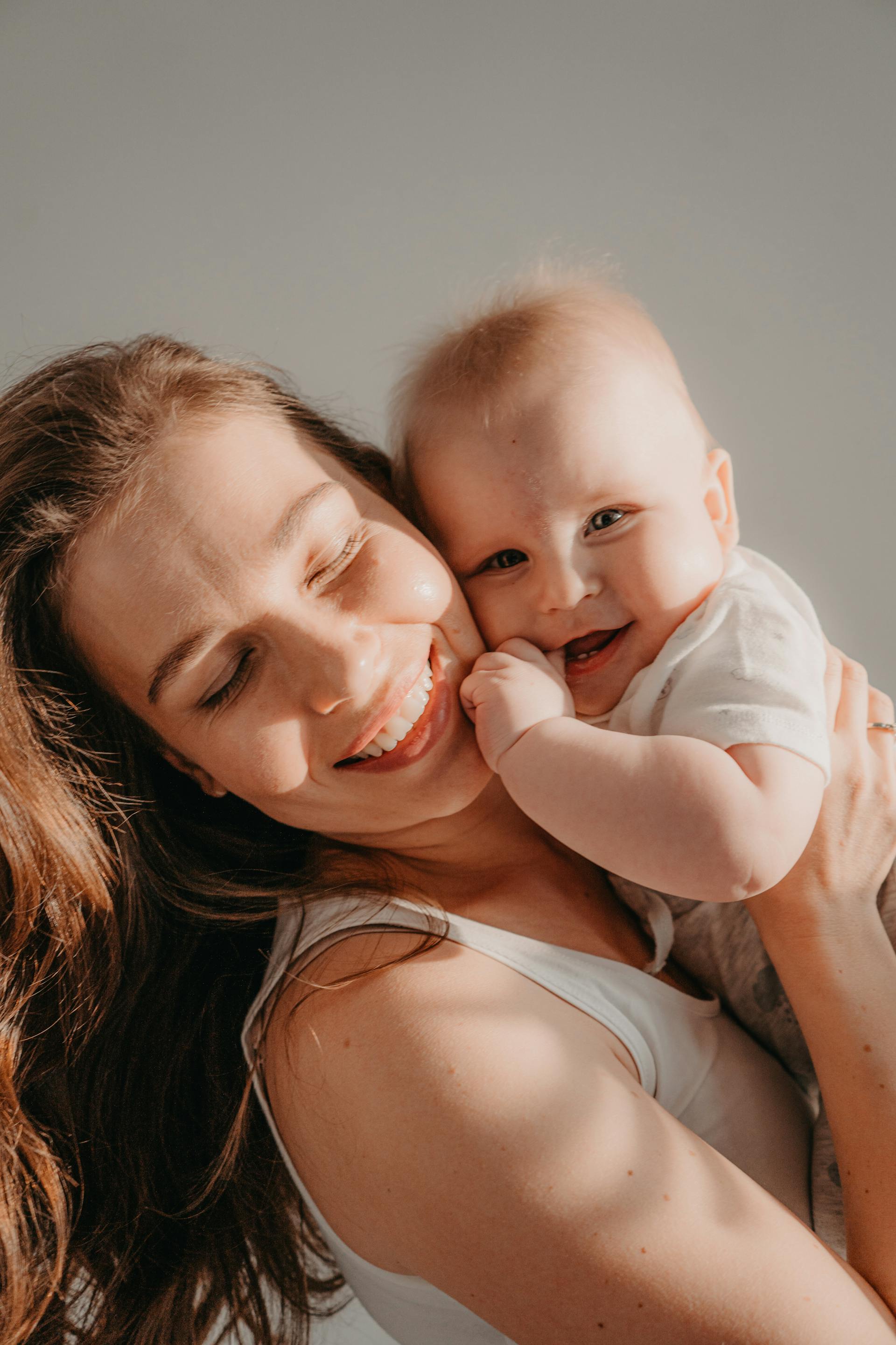 Une femme heureuse tenant un bébé souriant | Source : Pexels