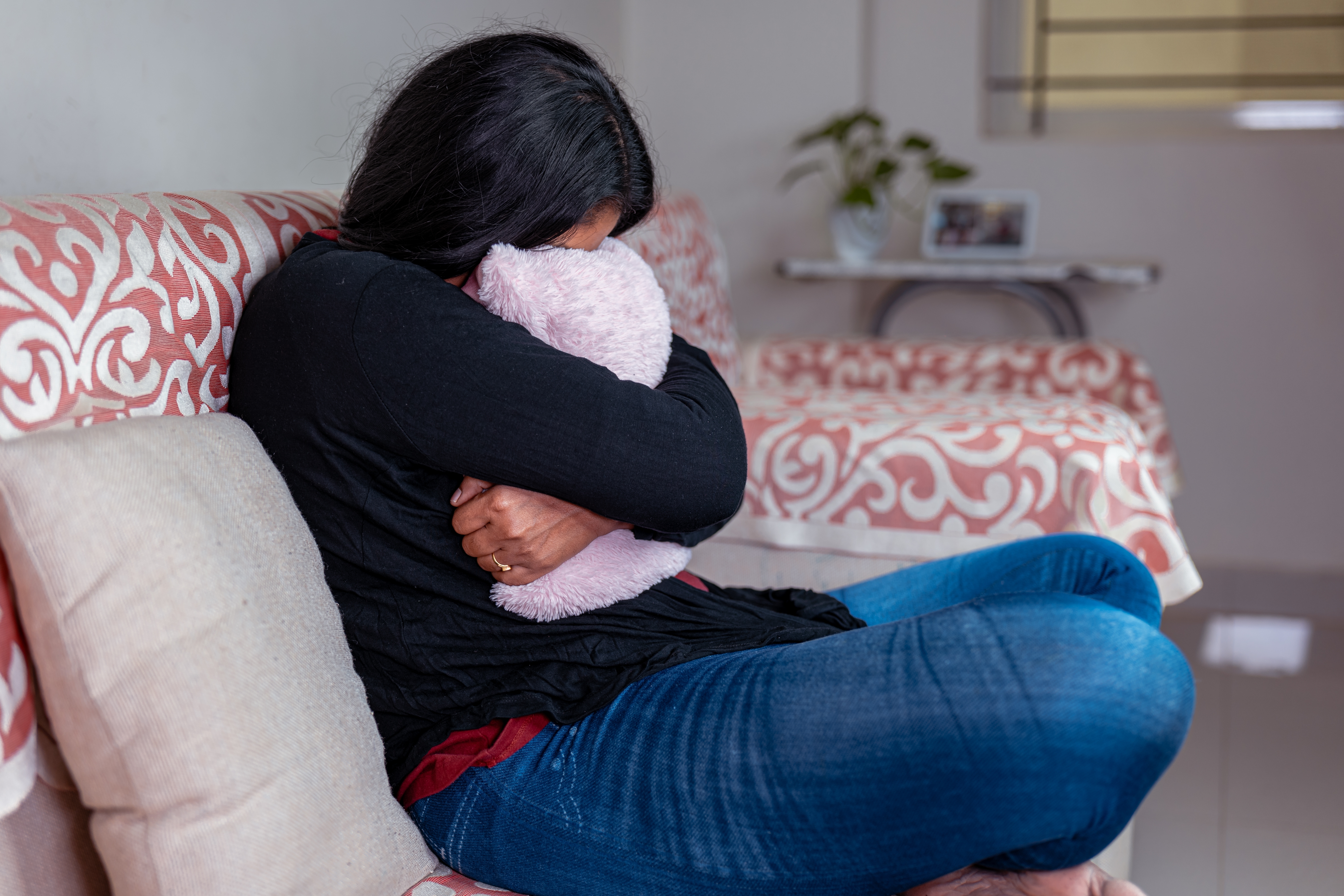 Jeune femme pleurant dans un oreiller | Source : Shutterstock