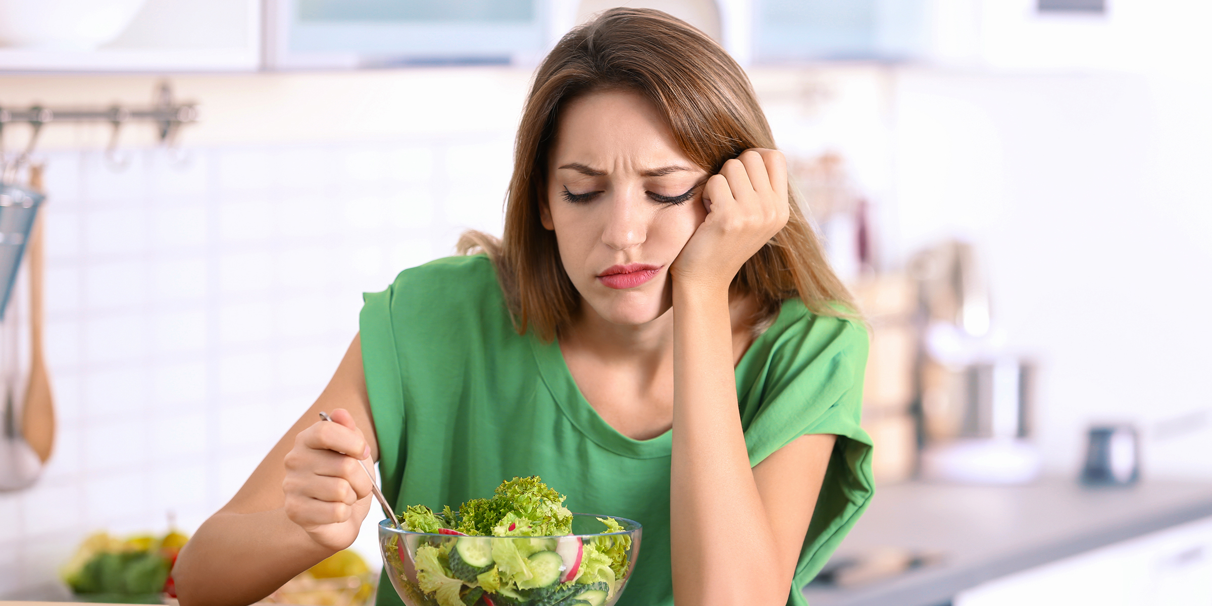 Une femme qui s'ennuie en regardant sa salade | Source : Shutterstock