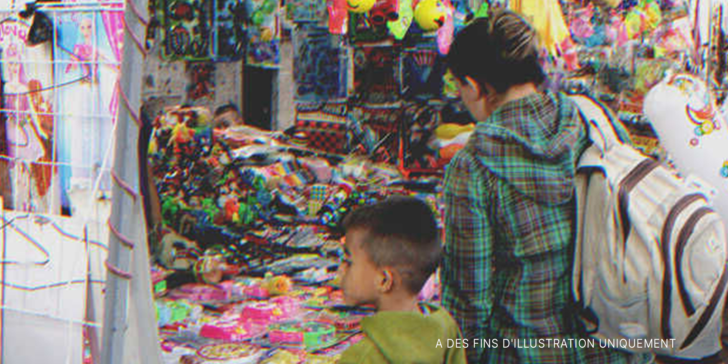Un garçon et sa mère devant un magasin de jouets | Source : Shutterstock