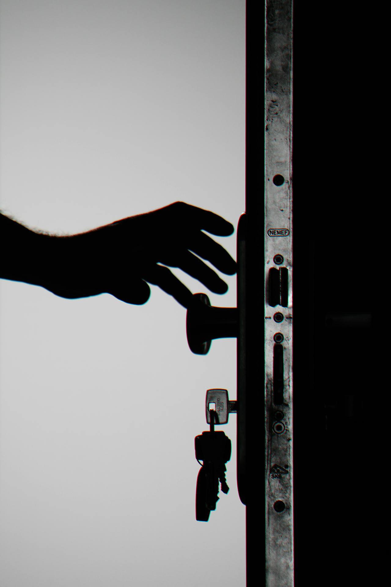 Silhouette d'une personne tendant la main pour attraper une poignée de porte | Source : Pexels