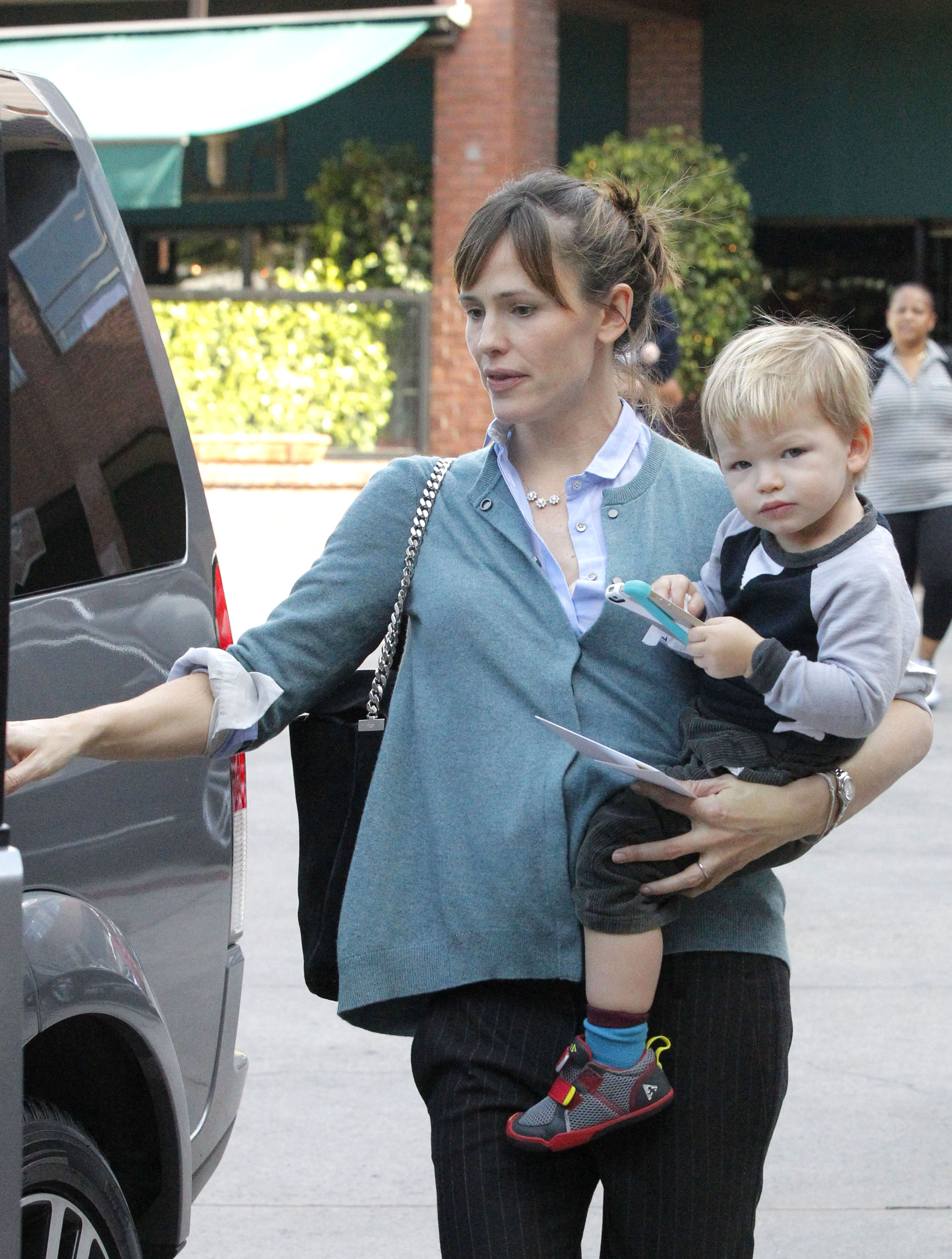 Samuel Garner Affleck regarde le photographe alors que sa mère, Jennifer Garner, le porte sur le chemin d'un véhicule, le 17 décembre 2013, dans le quartier de Brentwood à Los Angeles, en Californie. | Source : Getty Images