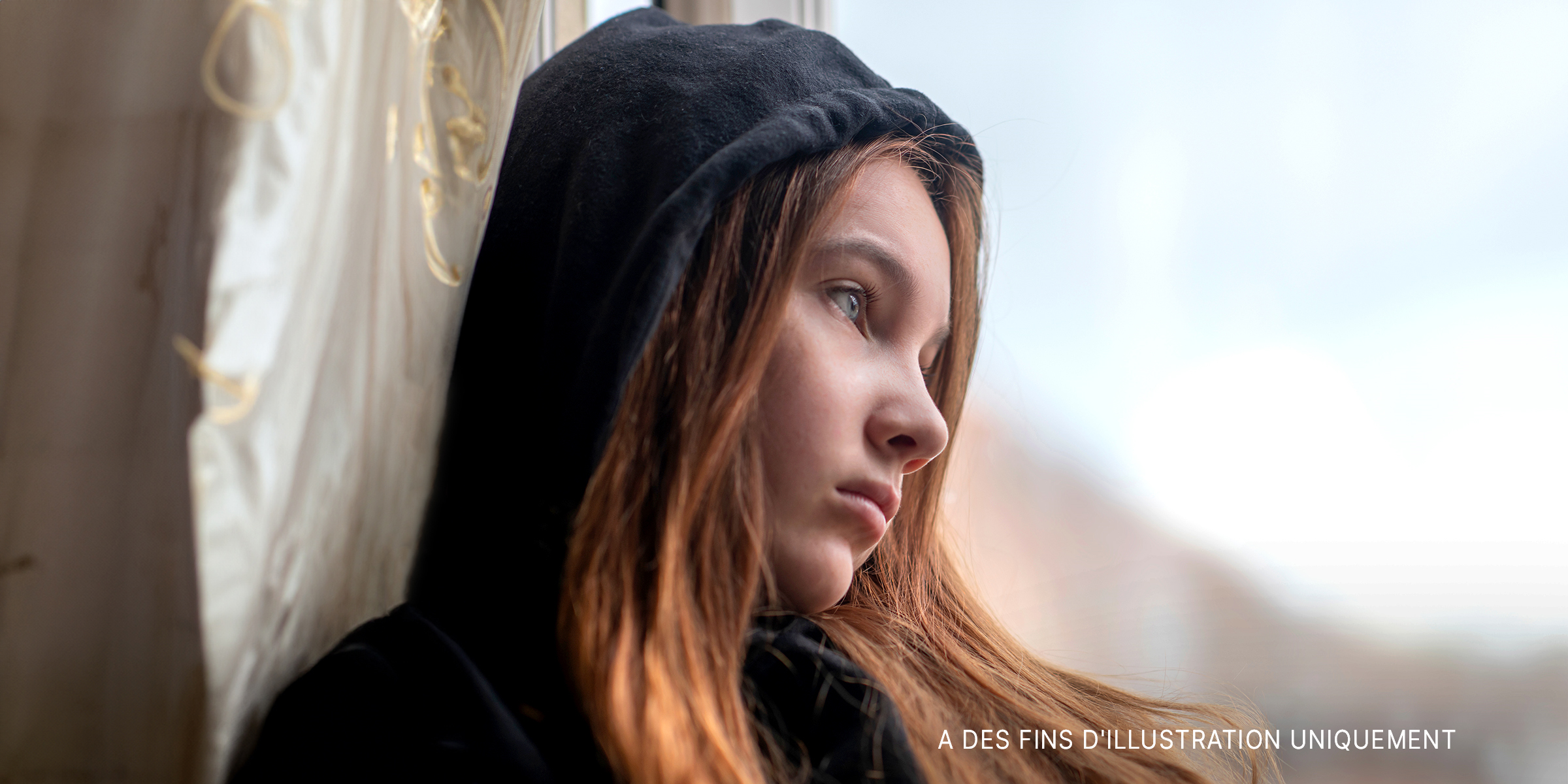 Une adolescente triste regarde par la fenêtre | Source : Shutterstock