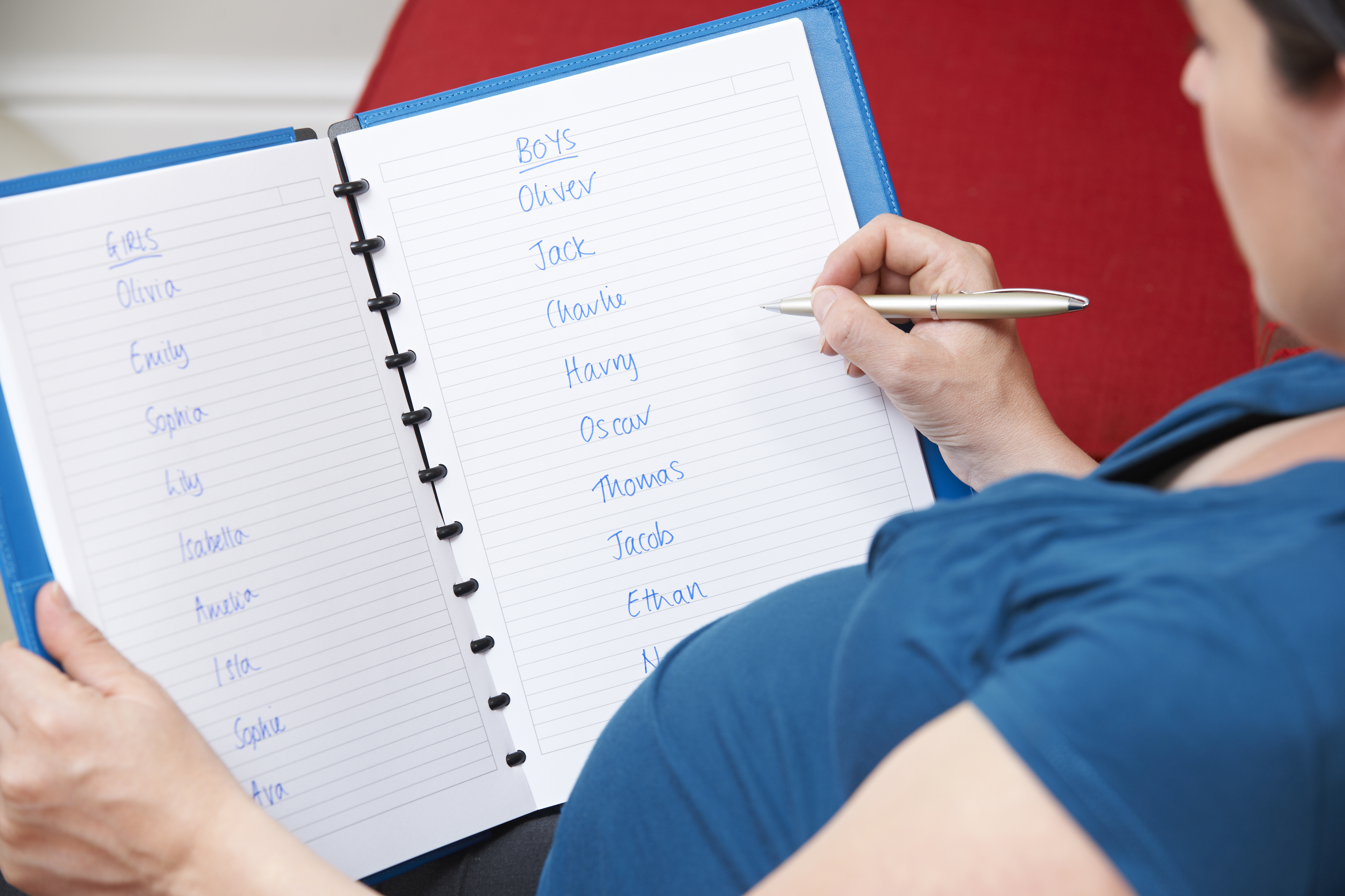 Une femme enceinte qui écrit des prénoms de bébé potentiels | Source : Shutterstock