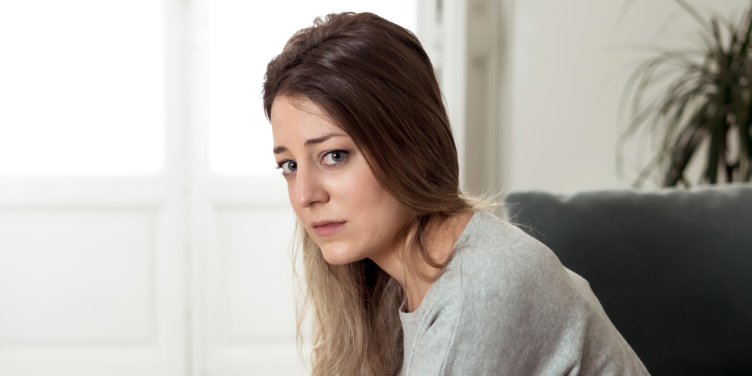 Une femme à l'air triste assise seule à la maison | Source : Shutterstock