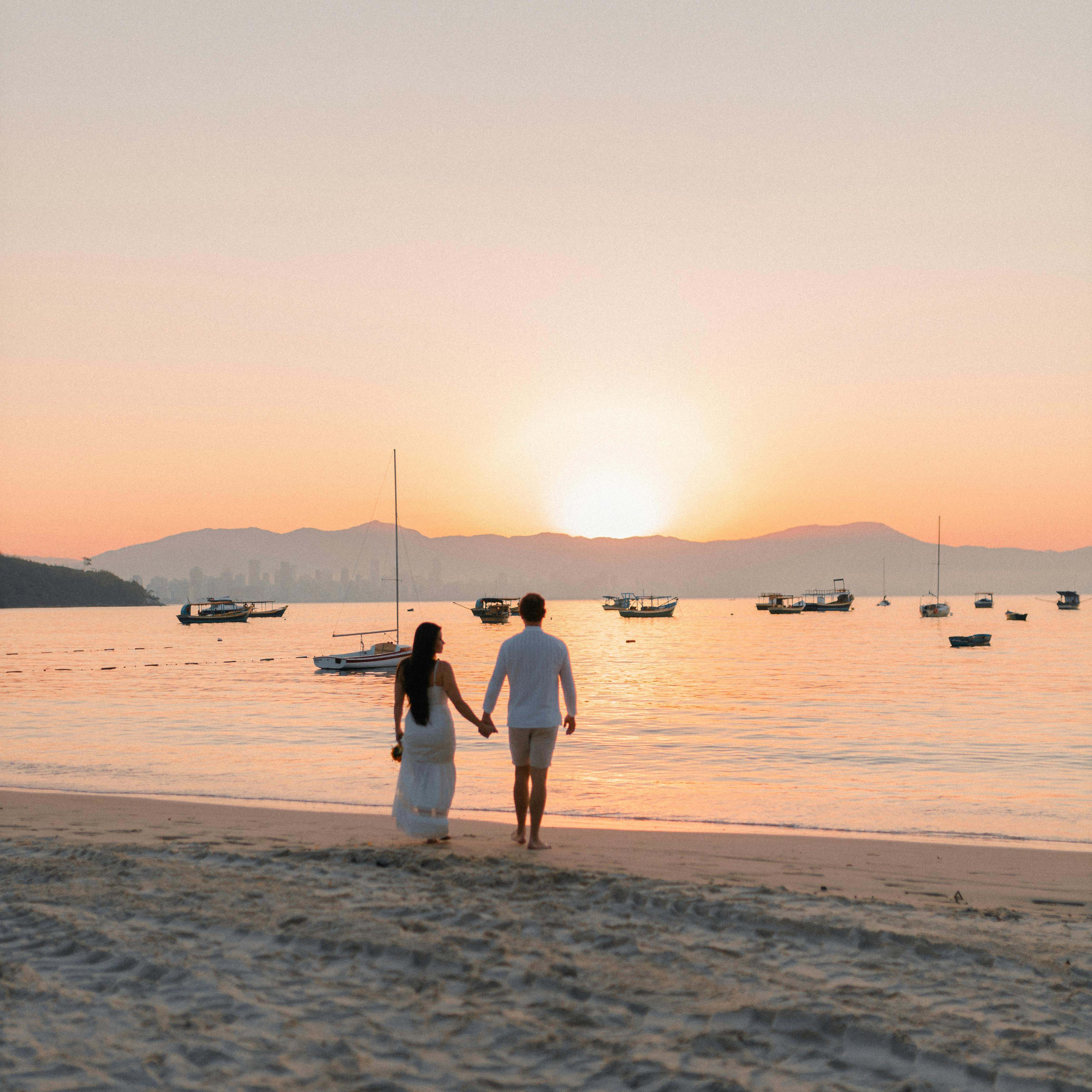 Un couple marchant sur une plage, se tenant par la main | Source : Pexels