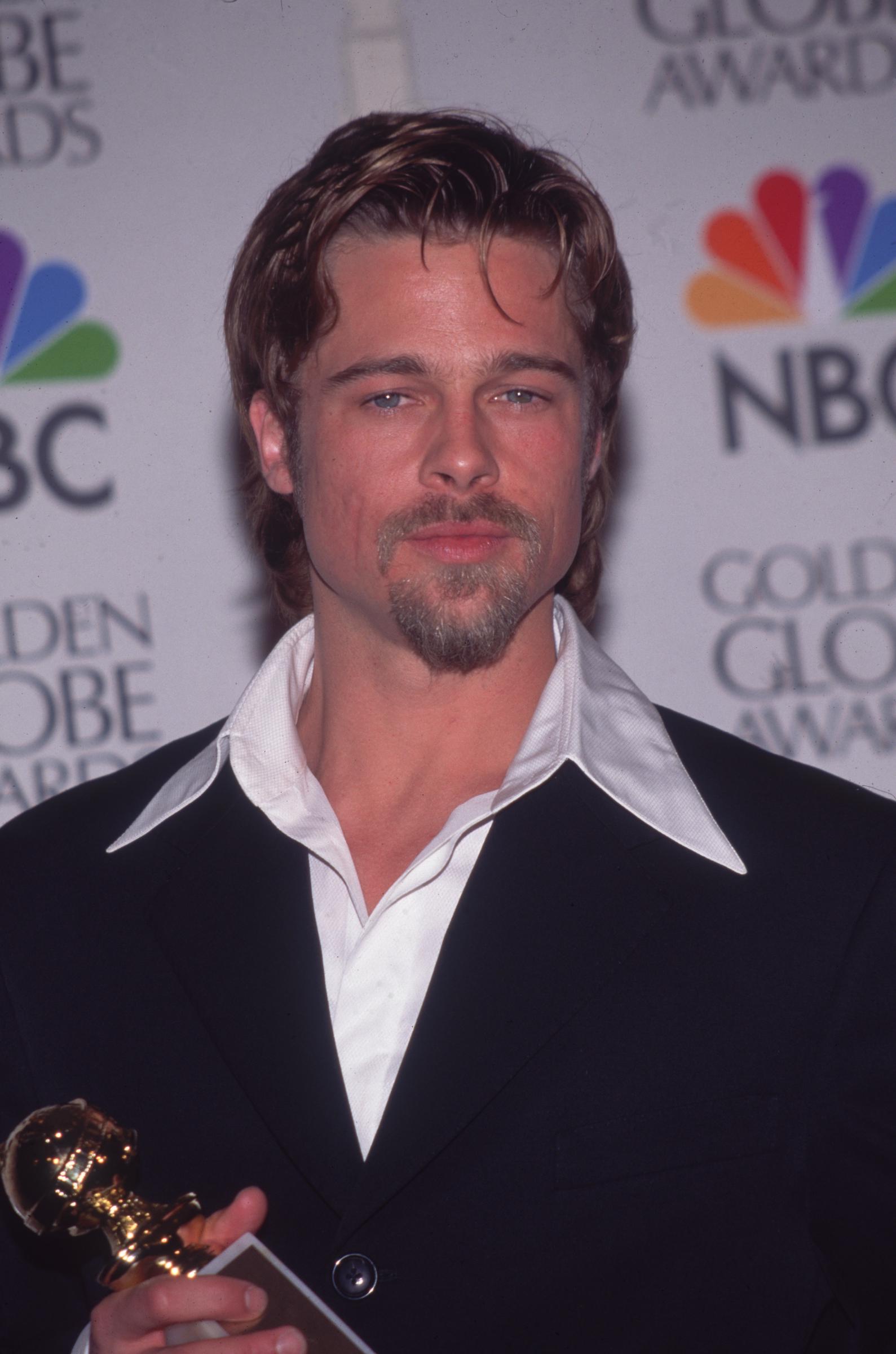 Brad Pitt tenant son Golden Globe Award du meilleur acteur dans un second rôle, le 1er janvier 1996, à Los Angeles, en Californie. | Source : Getty Images