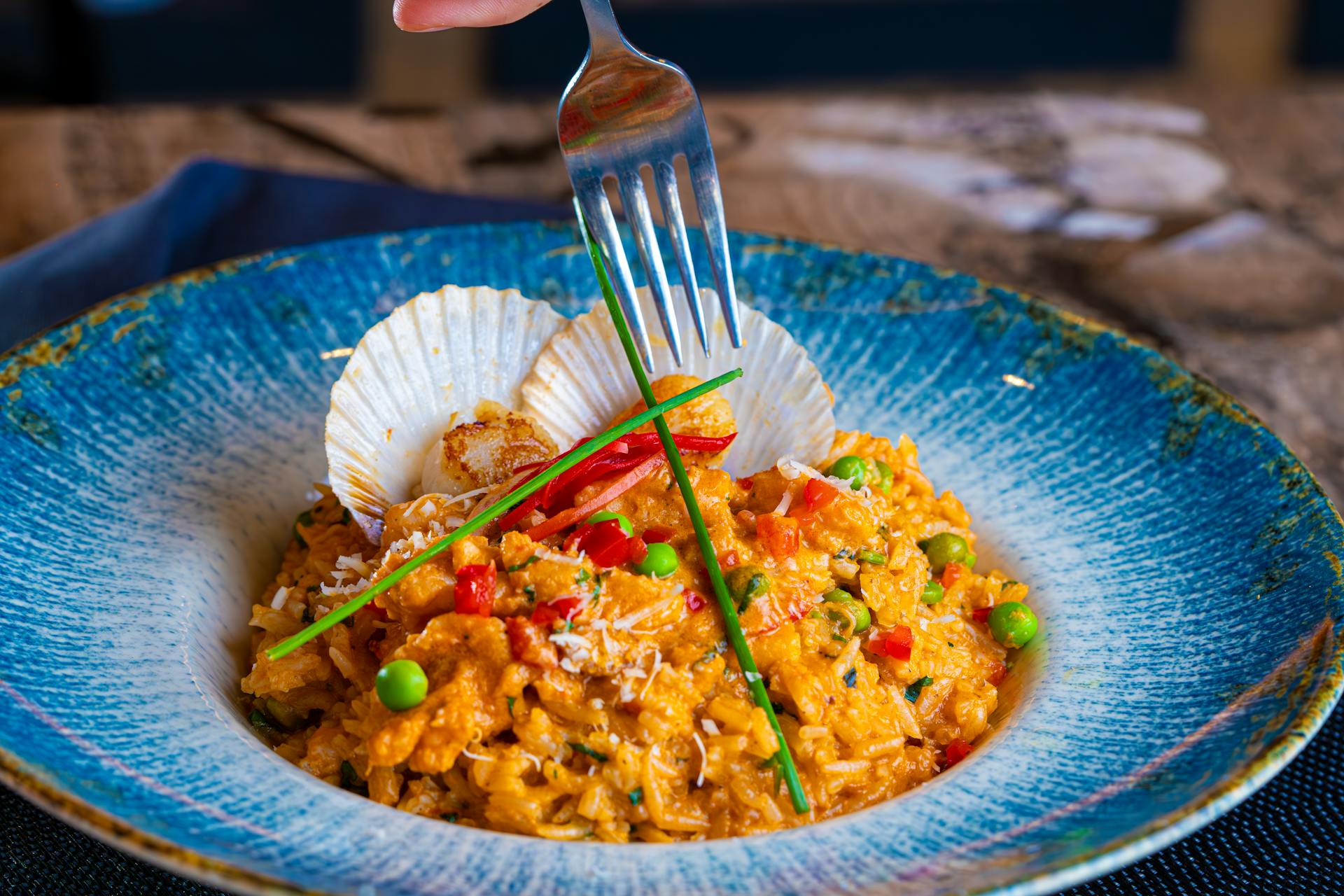 Une fourchette posée au-dessus d'une assiette de paella | Source : Pexels