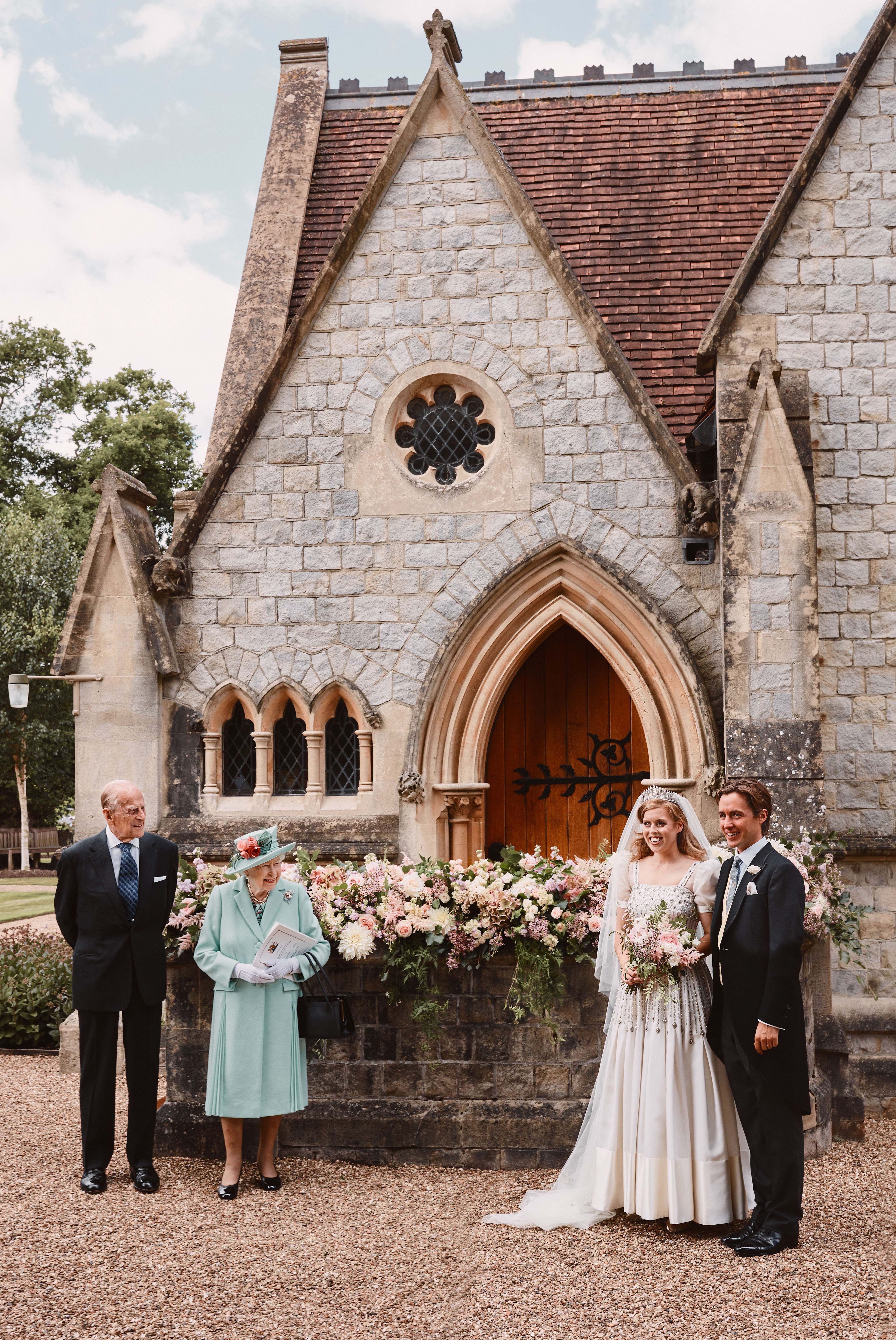 La princesse Beatrice et Edoardo Mapelli Mozzi se tiennent à l'extérieur de The Royal Chapel of All Saints at Royal Lodge, Windsor, après leur mariage, avec la reine Élisabeth II et le prince Philip, duc d'Édimbourg, le 18 juillet 2020, en Angleterre. | Source : Getty Images