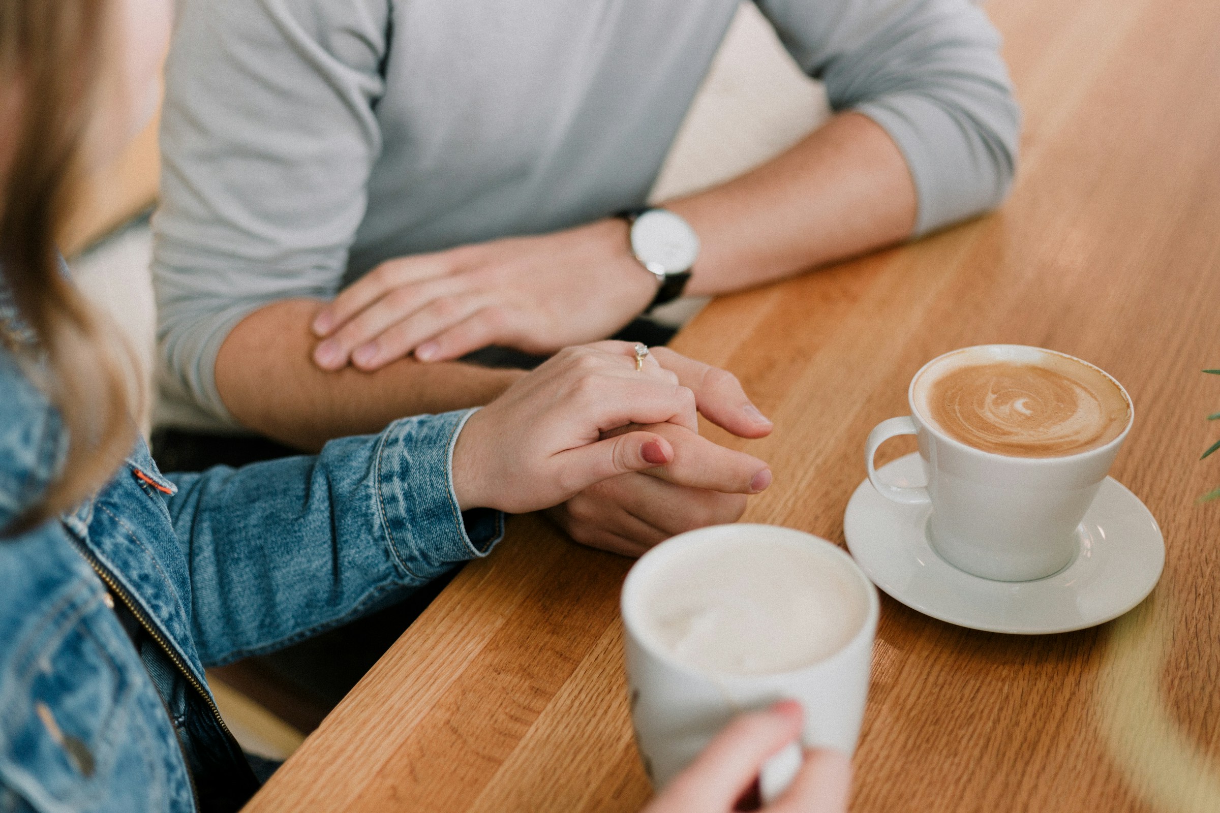 Gros plan d'un couple qui discute en prenant un café | Source : Unsplash