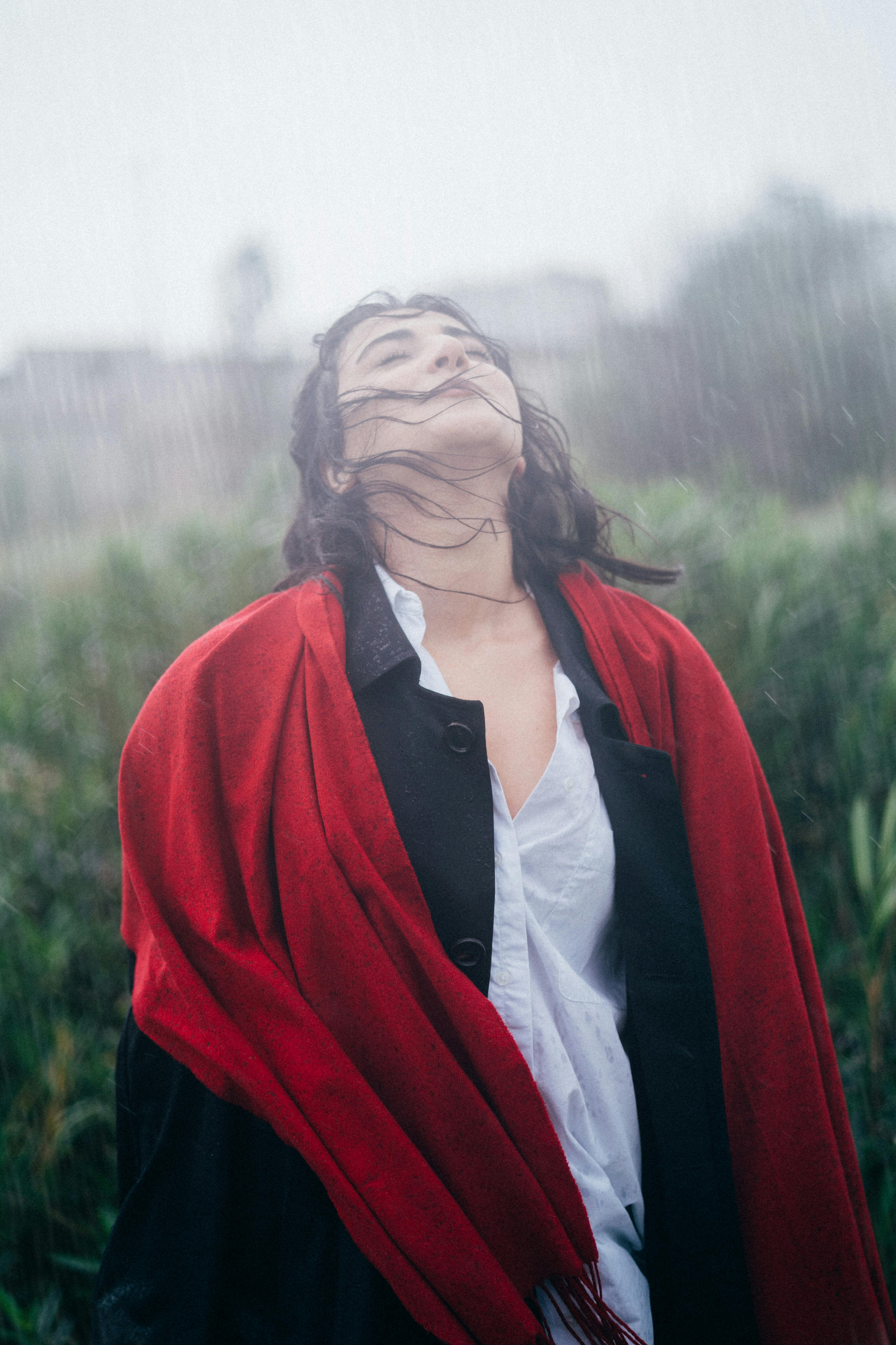 Une femme debout, les yeux fermés, sous la pluie | Source : Pexels