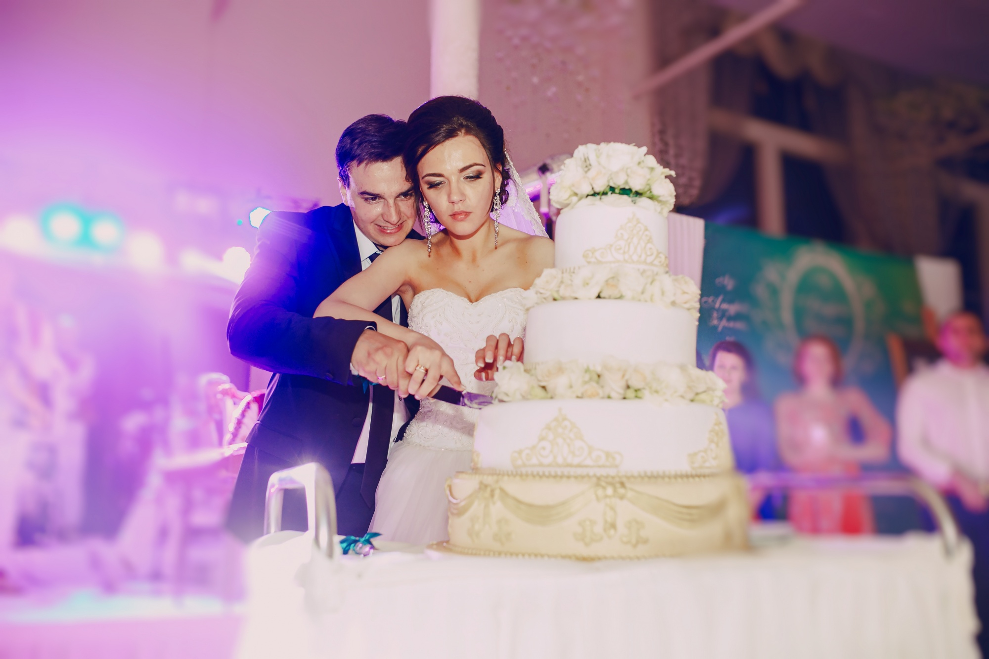 Une mariée et un marié coupant leur gâteau de mariage | Source : freepik
