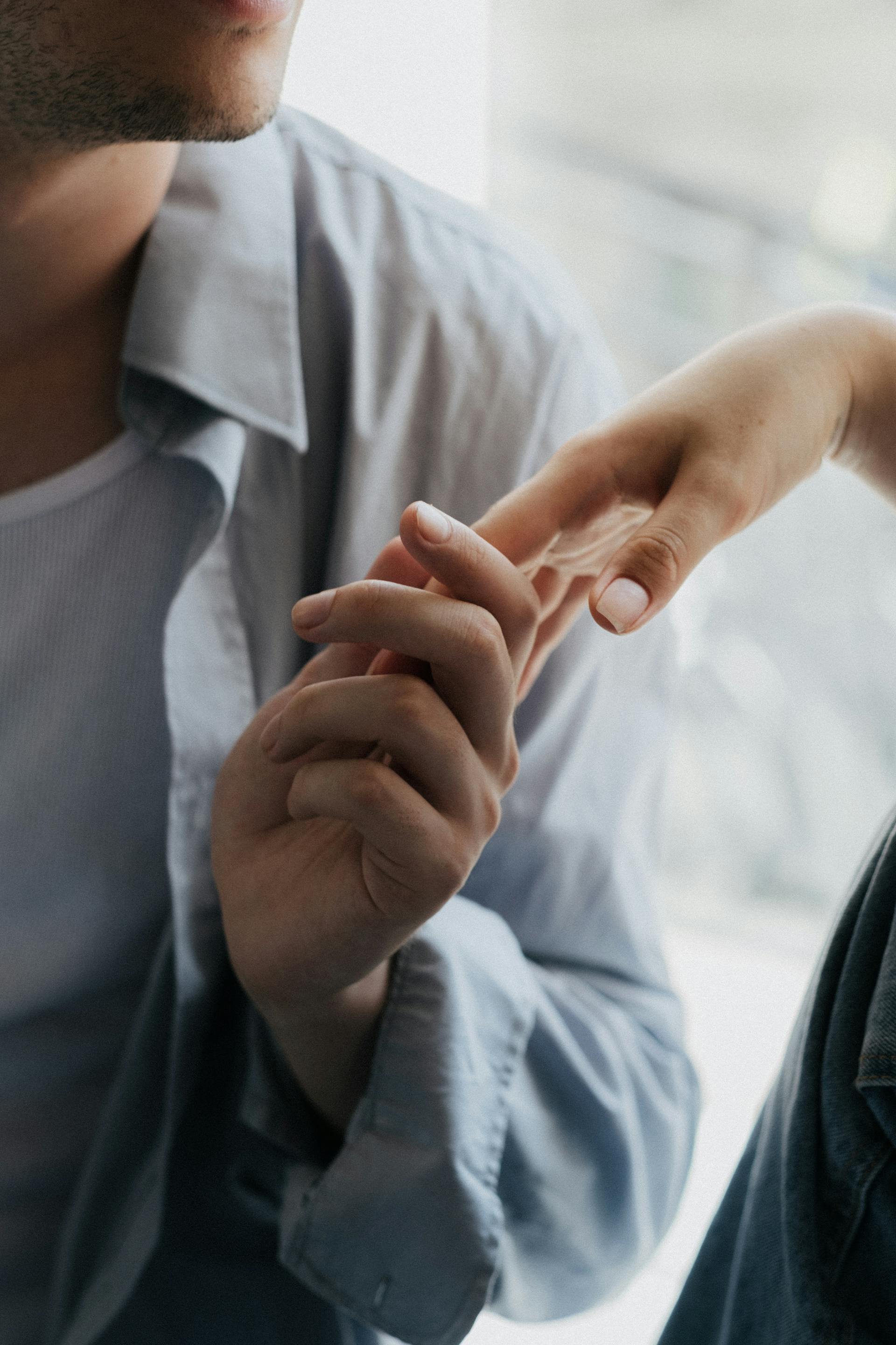 Un homme tenant délicatement la main d'une femme | Source : Pexels
