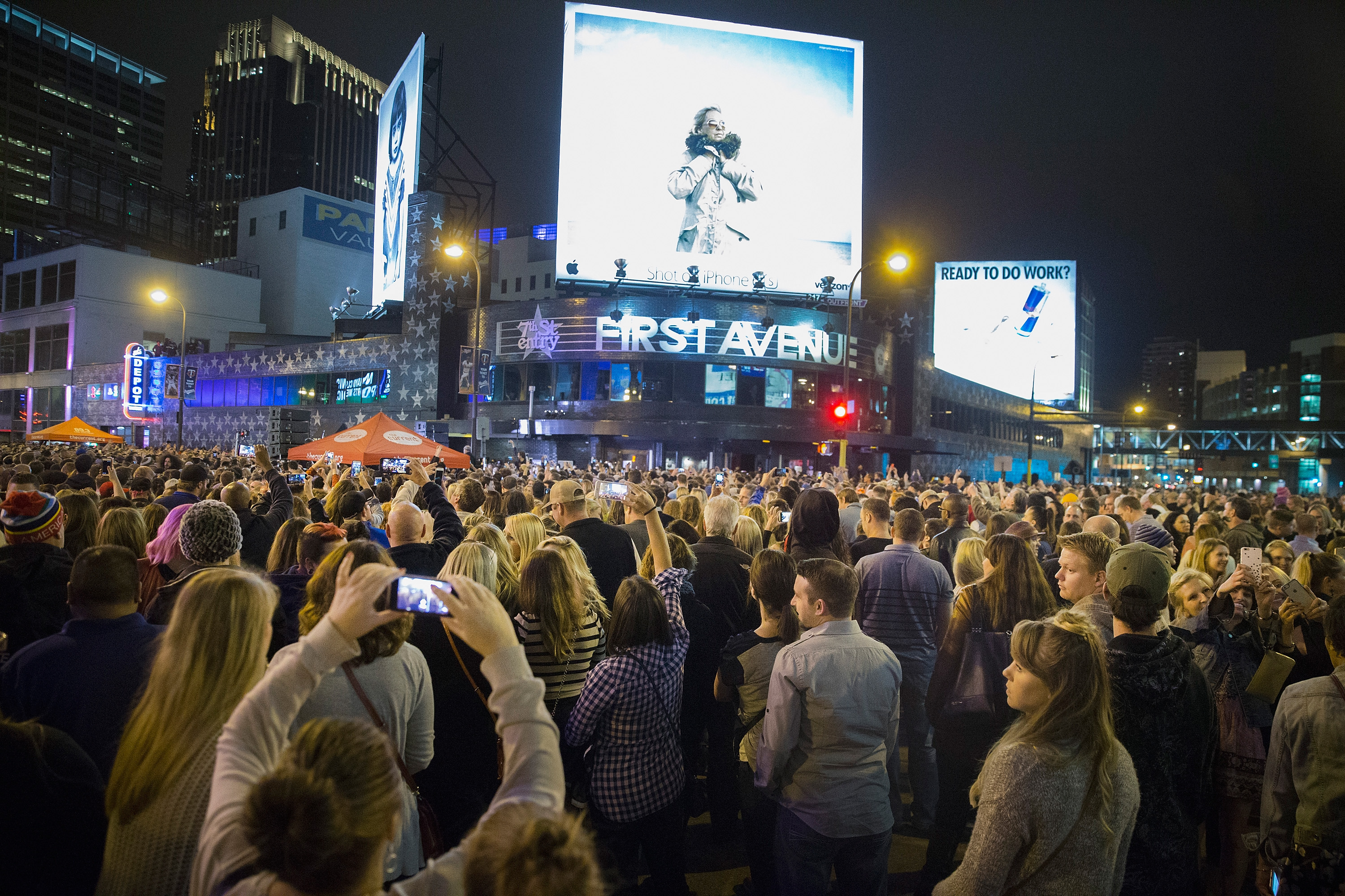 Des fans se rassemblent pour écouter la musique de Prince lors d'une fête de rue commémorative devant la boîte de nuit First Avenue à Minneapolis, Minnesota, le 21 avril 2016 | Source : Getty Images